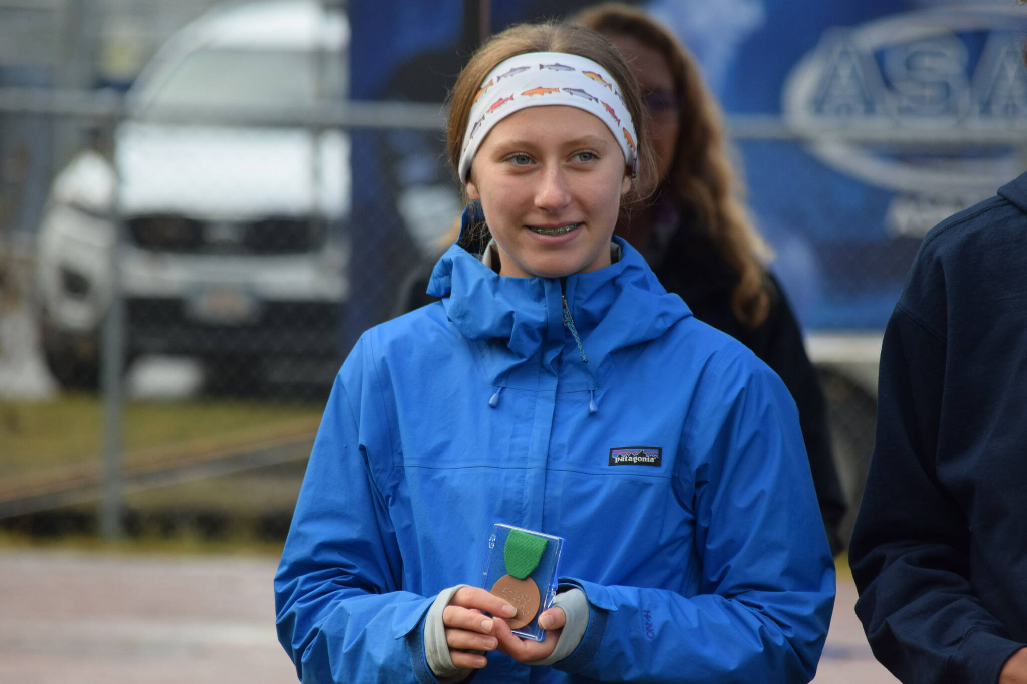 Hailey Ingalls of Seward gets a medal at the Division II state cross country championship at Bartlett High School in Anchorage, Alaska on Saturday, Oct. 9, 2021 for her fifth place finish. (Camille Botello/Peninsula Clarion)