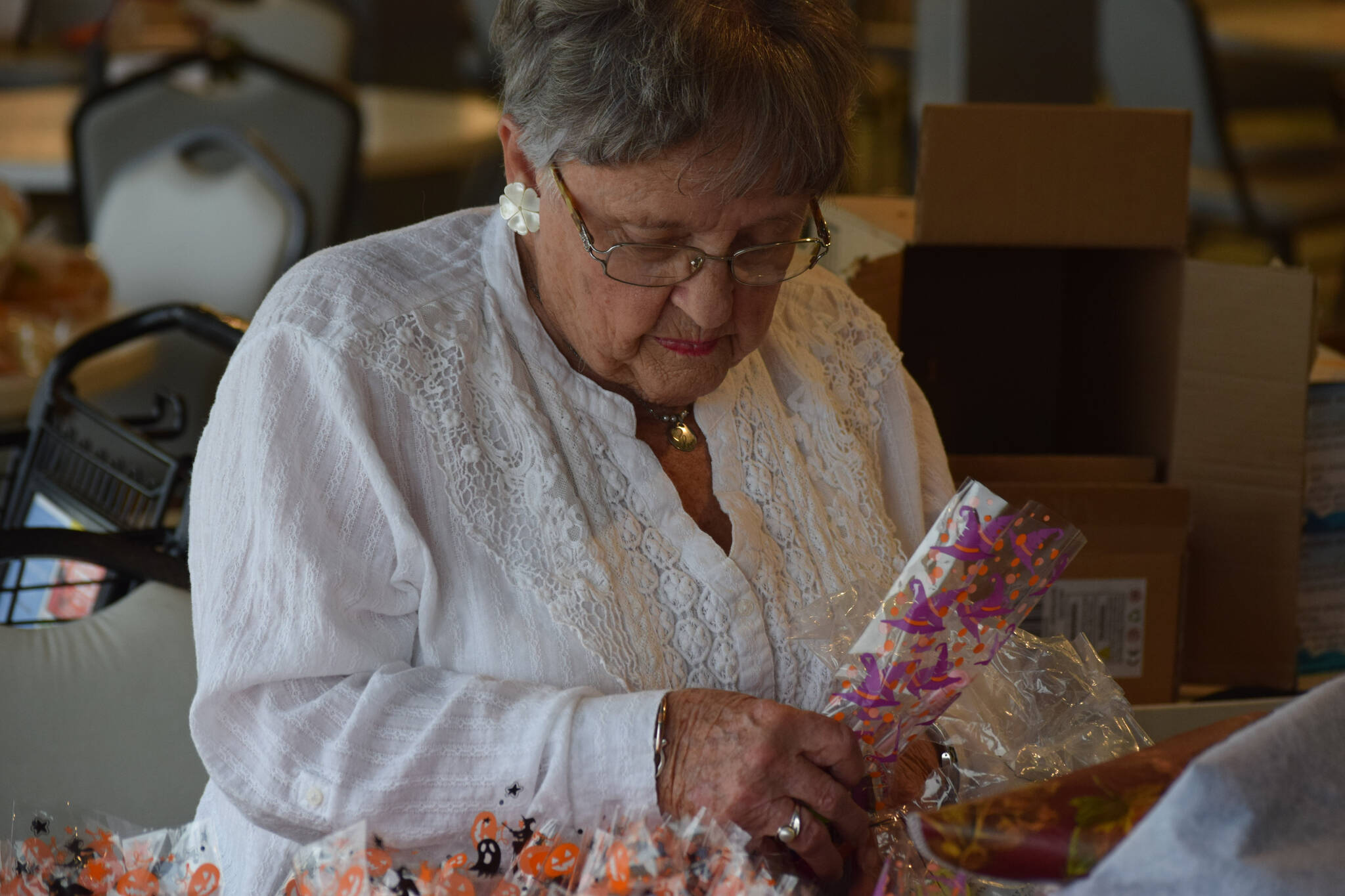 Velda Geller fills goodie bags at the Kenai Senior Center on Friday, Oct. 22, 2021 for next weekend’s drive-through trick-or-treat event. (Camille Botello/Peninsula Clarion)