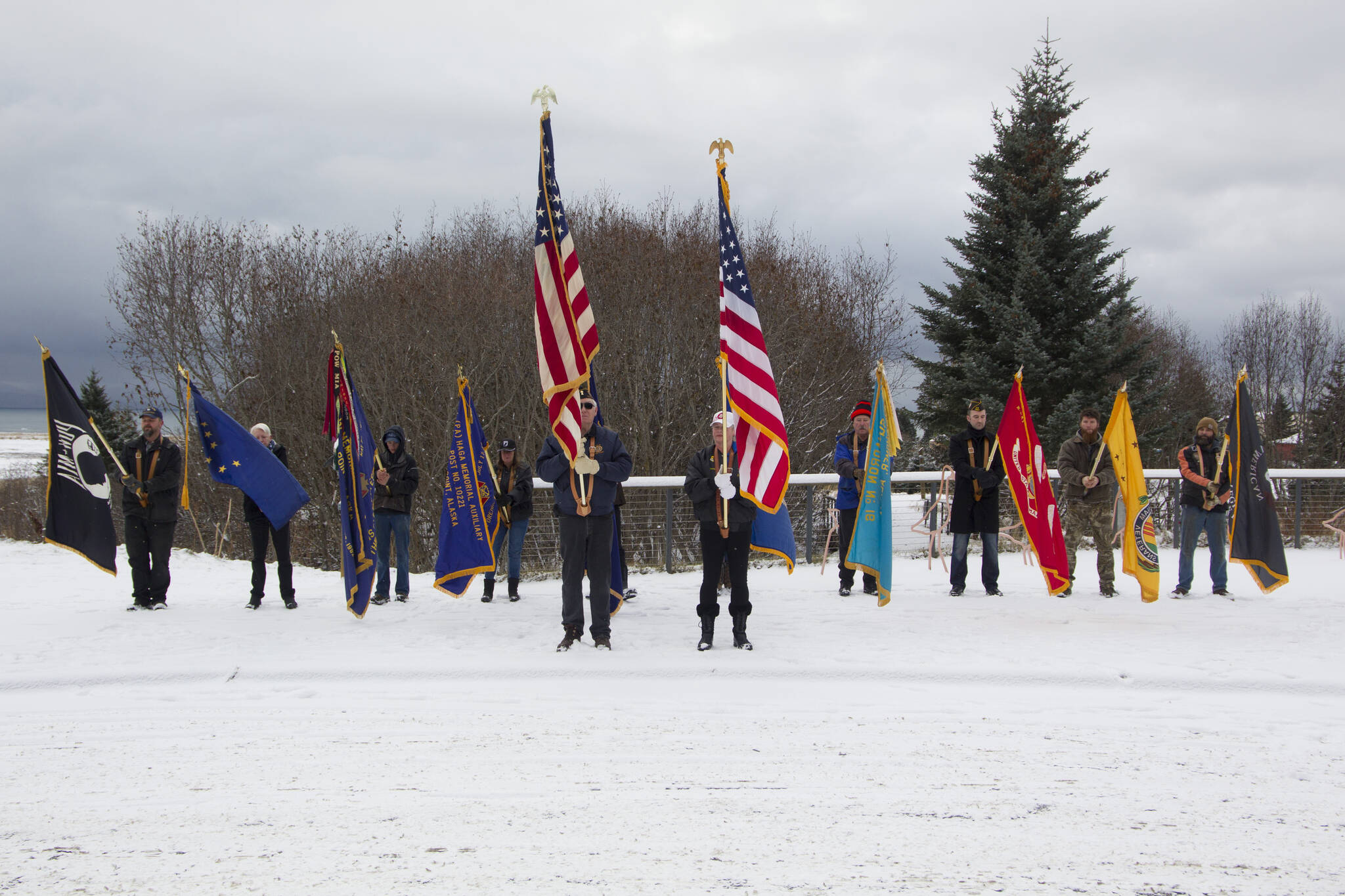 The color guard lowers the flags in honor of the veterans who have passed as Christie Hill plays “Taps” during the Veterans Day ceremony at the Alaska Islands and Ocean Visitor Center. (Photo by Sarah Knapp/Homer News)