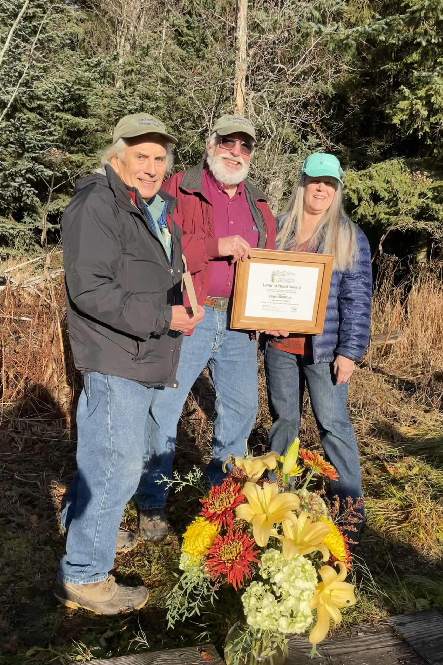 Dave Brann, left, and Robert Archibald, center, present Barb Seaman, right, with the Kachemak Heritage Land Trust Land at Heart Award on Nov. 9 at the Calvin Coyle Trail in Homer. (Photo provided by Kachemak Heritage Land Trust)