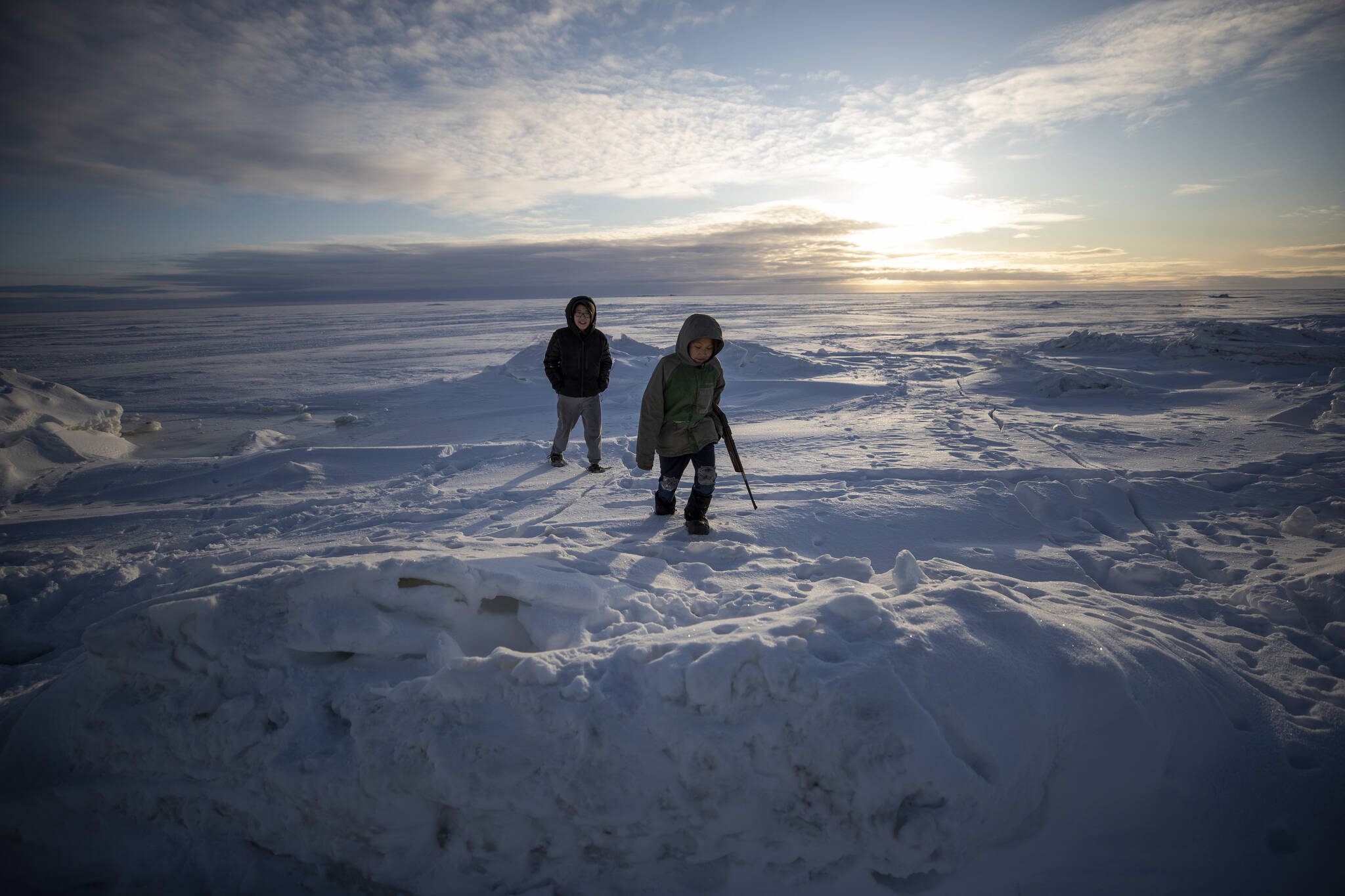 AP Photo/Gregory Bull,File
In this Saturday, Jan. 18, 2020, photo, George Chakuchin, left, and Mick Chakuchin look out over the Bering Sea near Toksook Bay, Alaska. A federal grant will allow an extensive trail system to connect all four communities on Nelson Island, just off Alaska’s western coast. The $12 million grant will pay to take the trail the last link, from Toksook Bay, which received the federal money, to the community of Mertarvik, the new site for the village of Newtok. The village is moving because of erosion.