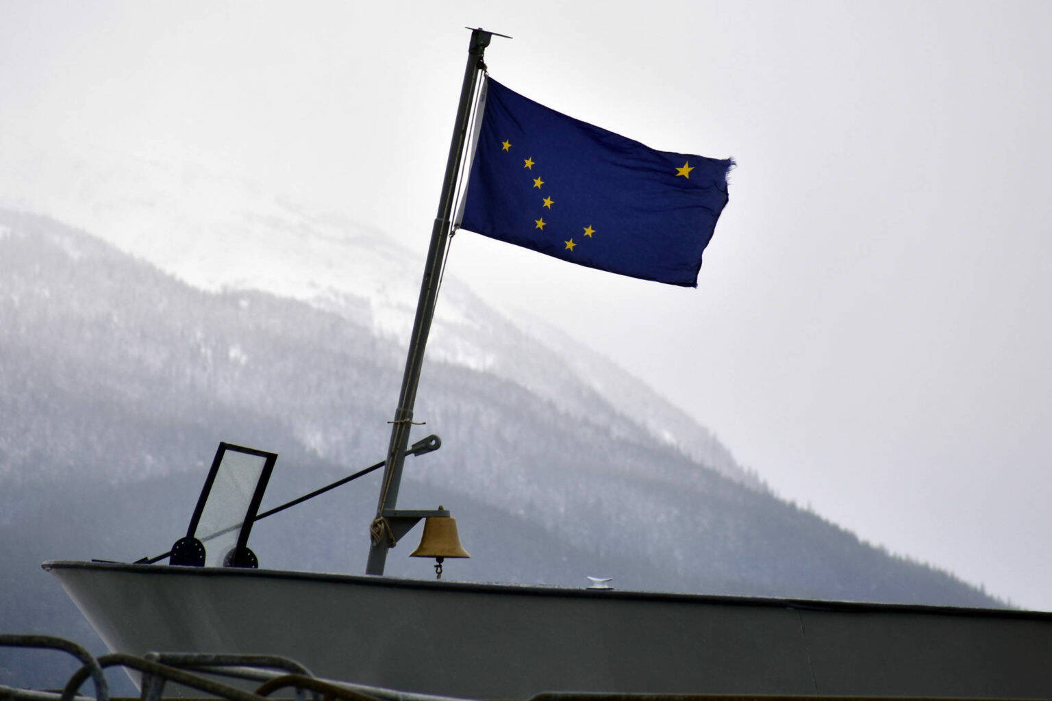 This February 2020 file photo shows the Alaska state flag on the bow of the MV Matanuska at the Auke Bay Ferry Terminal. The infrastructure bill recently passed by Congress includes significant funding for the ferry system, but coastal communities are still feeling the pinch of reduced service. (Peter Segall / Juneau Empire file)