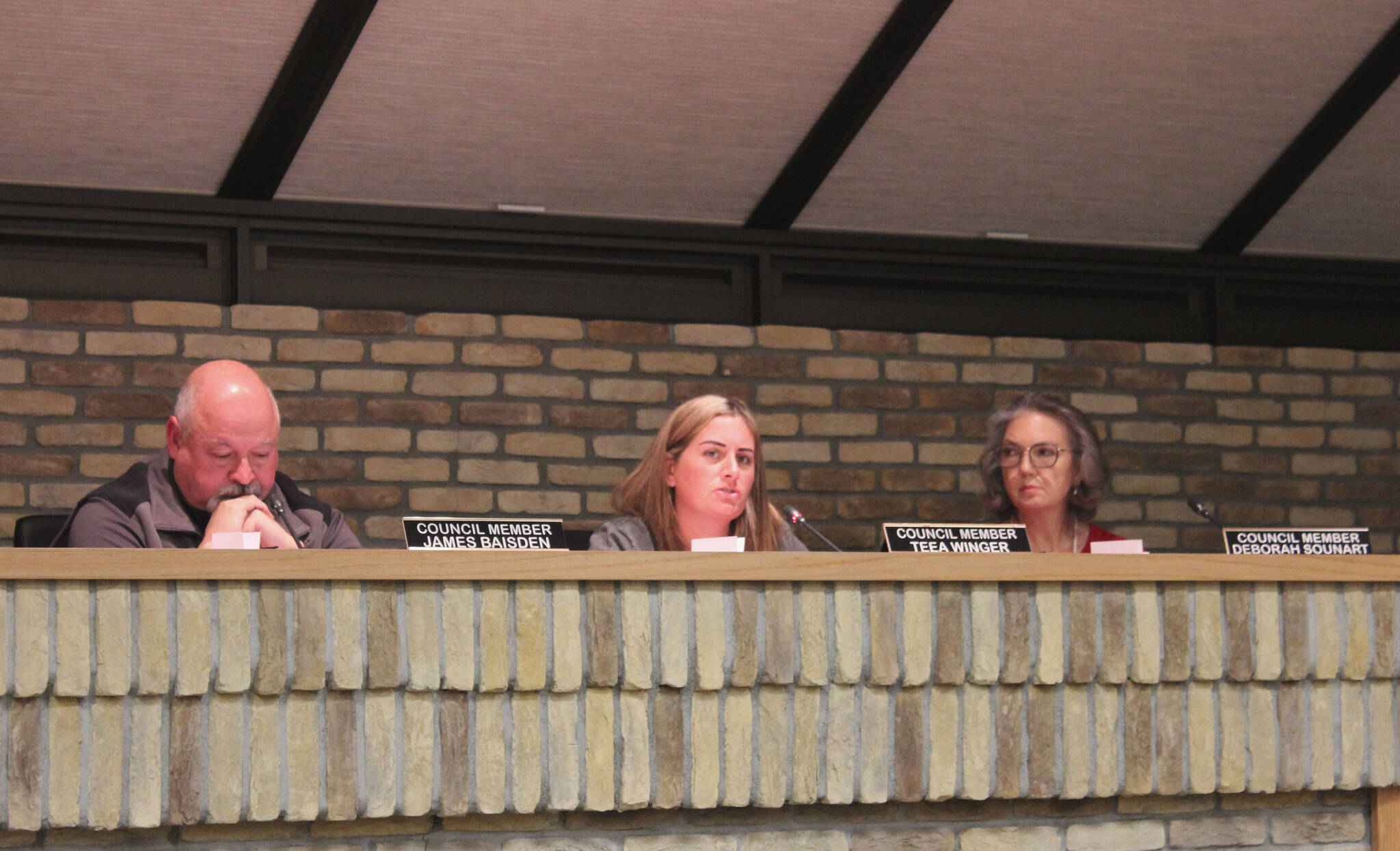 Kenai City Council members James Baisden (left) and Deborah Sounart (right) listen as member Teea Winger (center) speaks in support of legislation opposing government COVID-19 mandates, during a meeting of the Kenai City Council last Wednesday, in Kenai.