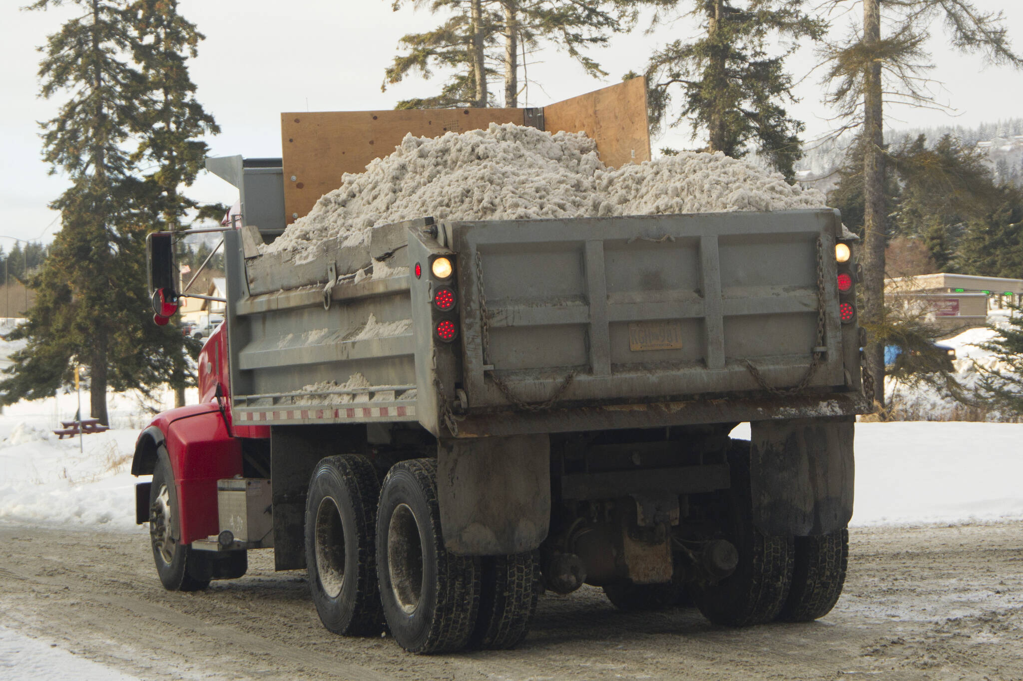 A truck filled with snow recently plowed from local roads backs up to dump the snow. (Photo by Sarah Knapp/Homer News)