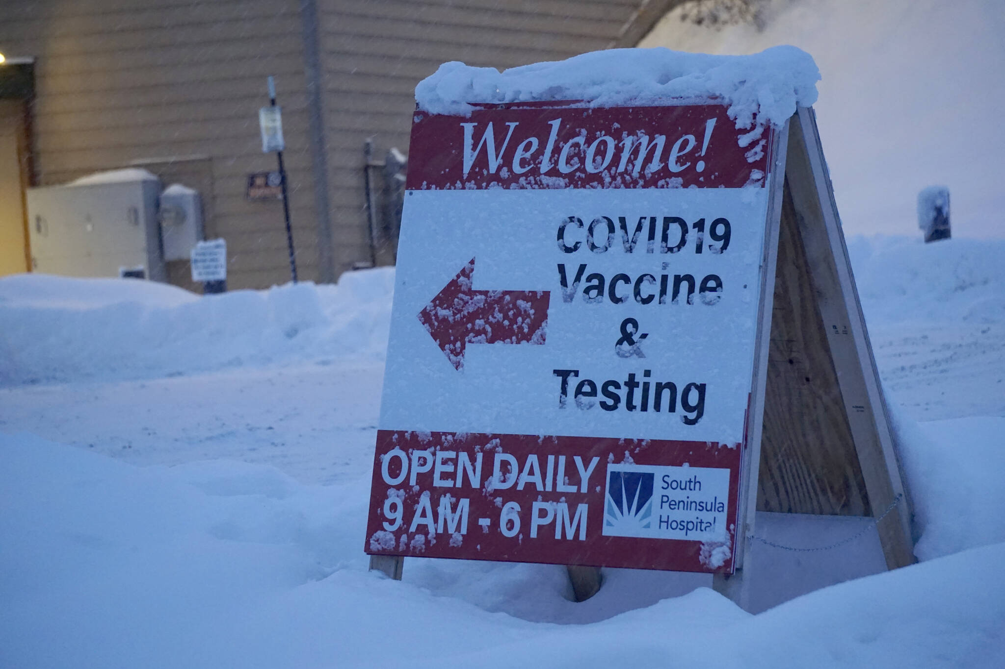 Snow covers the sign on Thursday, Dec. 9, 2021, at the South Peninsula Hospital Bartlett Street COVID-19 testing and vaccination clinic in Homer, Alaska. (Photo by Michael Armstrong/Homer News)