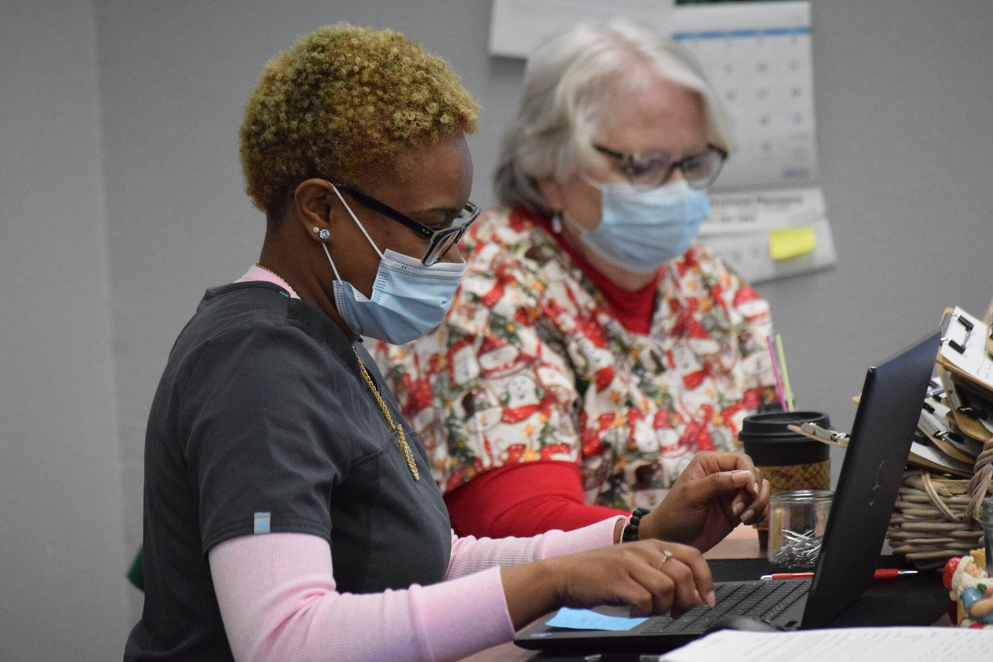 Certified nursing assistant KaDaisjah Roberts, left, and nurse Debbie Aubin, right, work at the “Y” vaccine clinic in Soldotna on Dec. 22, 2021. (Camille Botello/Peninsula Clarion)