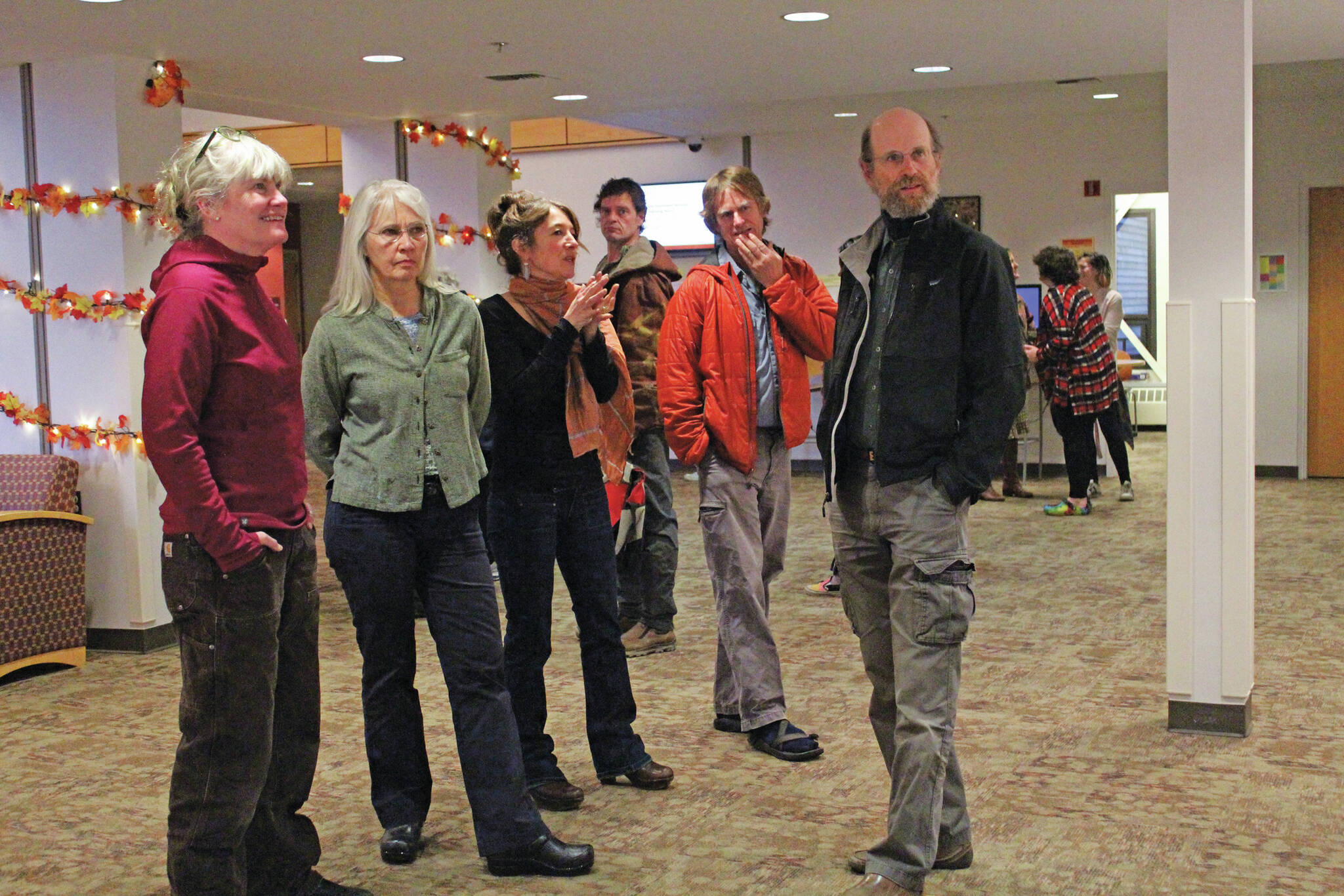 Artist Asia Freeman, third from left, speaks to visitors at a First Friday art exhibit opening featuring pieces by students in a college class she teaches, on Friday, Nov. 1, 2019, at Kachemak Bay Campus in Homer. (Photo by Megan Pacer/Homer News)