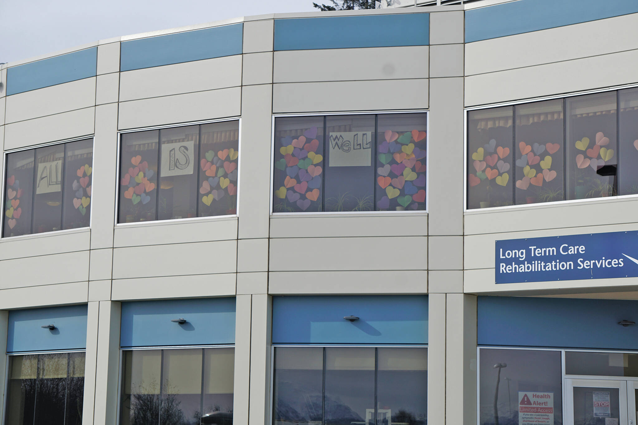 At the start of the COVID-19 pandemic in March of 2020, signs in the windows of the Long Term Care wing at South Peninsula Hospital in Homer, Alaska, say “All is well.” (Photo by Michael Armstrong/Homer News)