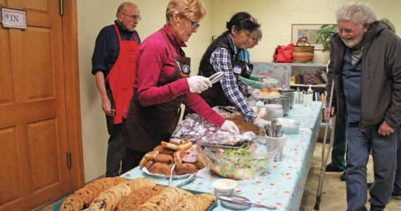 Volunteers distibute a meal to attendees at Project Homeless Connect on Jan. 29, 2020 at Homer United Methodist Church in Homer, Alaska. The event is a one-day opportunity for the homeless to get access to necessary supplies and services. (Photo by Megan Pacer/Homer News)