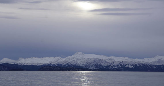 Clouds obscure the sun on Monday, Jan. 18, 2022, as seen from the Mariner Park beach in Homer, Alaska. Yukon Island is in the distance. Almost a month after the winter solstice, the sun rises higher in the sky at mid-day. (Photo by Michael Armstrong/Homer News)