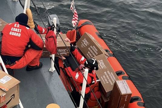Courtesy photo / USCG
Petty Officer 2nd Class Roy Jamison hands boxes of donated goods down to Lt. J.g. Matthew Hall as they prepare to ferry them to Wrangell harbor via the Coast Guard Cutter Anacapa’s small boat.
