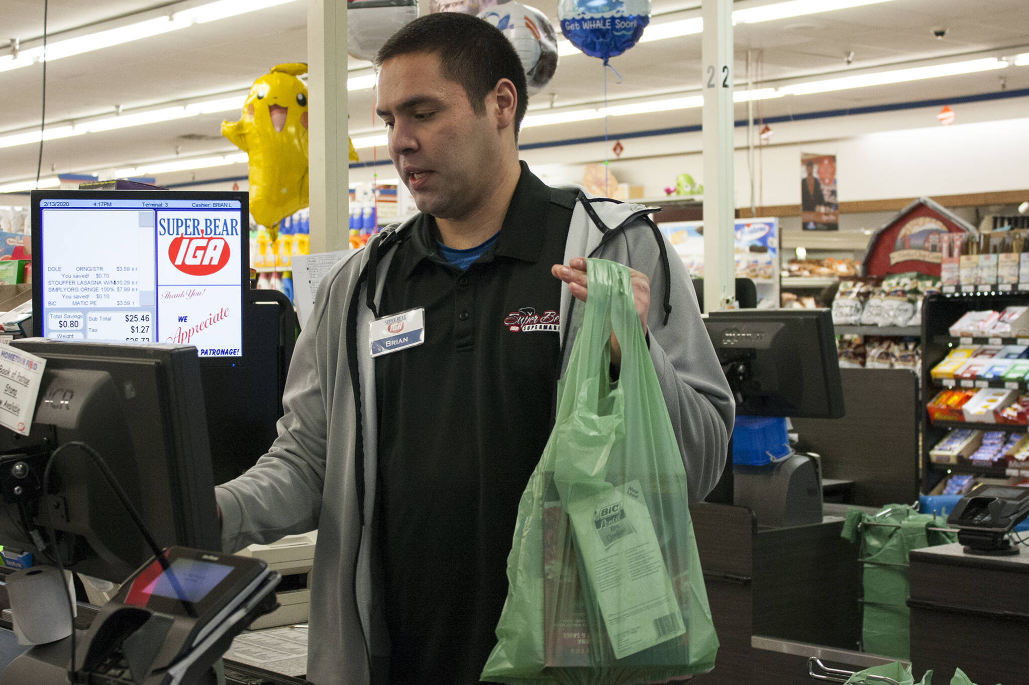 Brian Lauth, closing manager for Super Bear Supermarket IGA, bags groceries Thursday, Feb. 13, 2020. Next month, the Finance Committee for the City and Borough of Juneau will consider whether to exempt grocery purchases from the city's sales tax. (Ben Hohenstatt/Juneau Empire File)