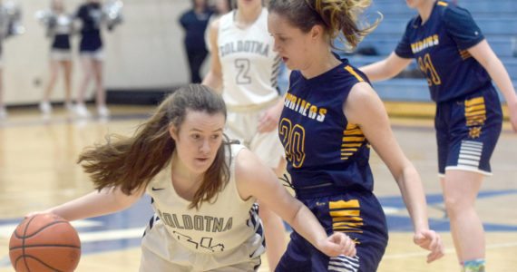 Soldotna’s Tanner Inman looks to drive on Homer’s Mel Morris on Thursday, Feb. 17, 2022, at Soldotna High School in Soldotna, Alaska. (Photo by Camille Botello/Peninsula Clarion)