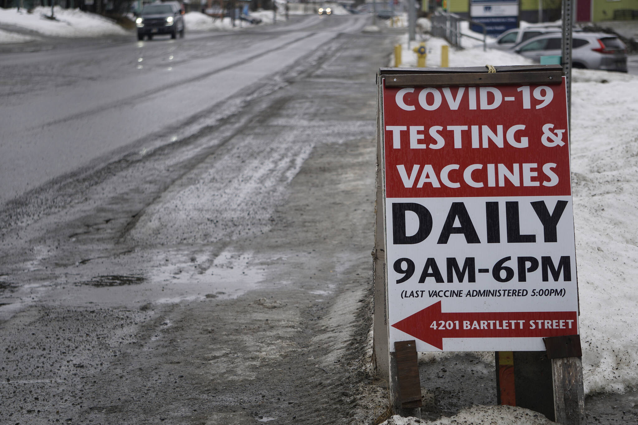 A sign at the corner of Pioneer Avenue and Bartlett Street points the way to the South Peninsula Hospital COVID-19 testing and vaccine clinic on Bartlett Street on Feb. 17, 2021, in Homer, Alaska. (Photo by Michael Armstrong/Homer News)
