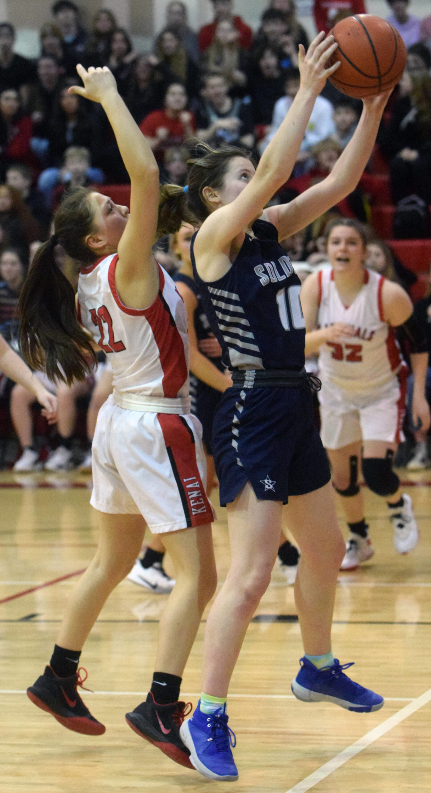 Soldotna’s Kaitlyn McAnelly grabs a rebound in front of Kenai Central’s Emilee Wilson on Friday, Feb. 25, 2022, at Kenai Central High School in Kenai, Alaska. (Photo by Jeff Helminiak/Peninsula Clarion)
