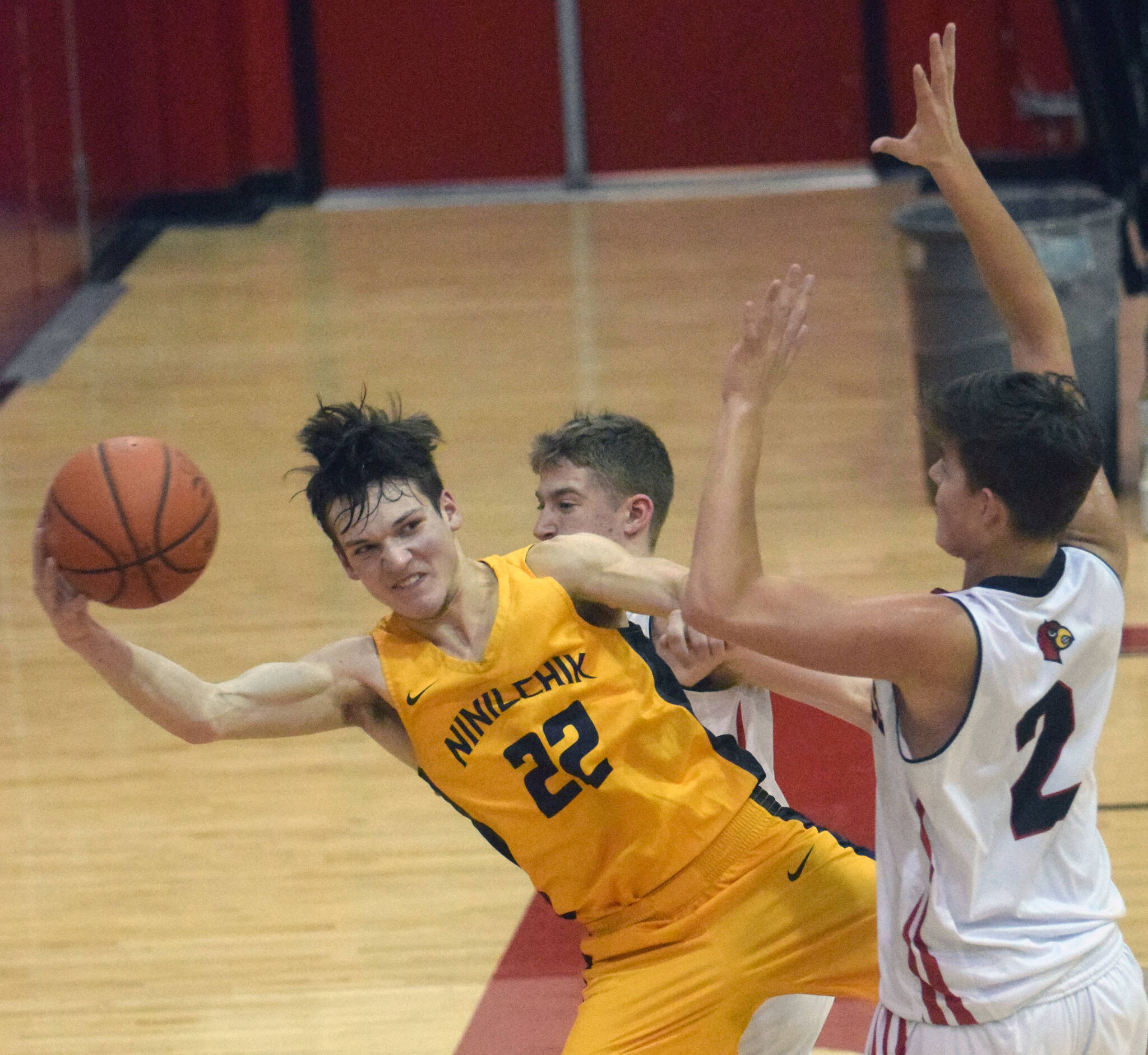 Ninilchik’s Justin Trail saves the ball in front of Kenai Central’s Luke Armstrong and Eli McCubbins on Saturday, March 5, 2022, at Kenai Central High School in Kenai, Alaska. (Photo by Jeff Helminiak/Peninsula Clarion)