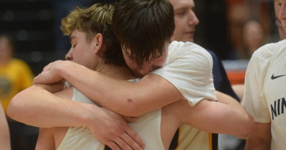 Justin Trail embraces Landon Colburn after the Ninilchik Wolverines won the Class 2A state basketball championship game at the Alaska Airlines Center in Anchorage, Alaska, on Saturday, March 19, 2022. (Camille Botello/Peninsula Clarion)