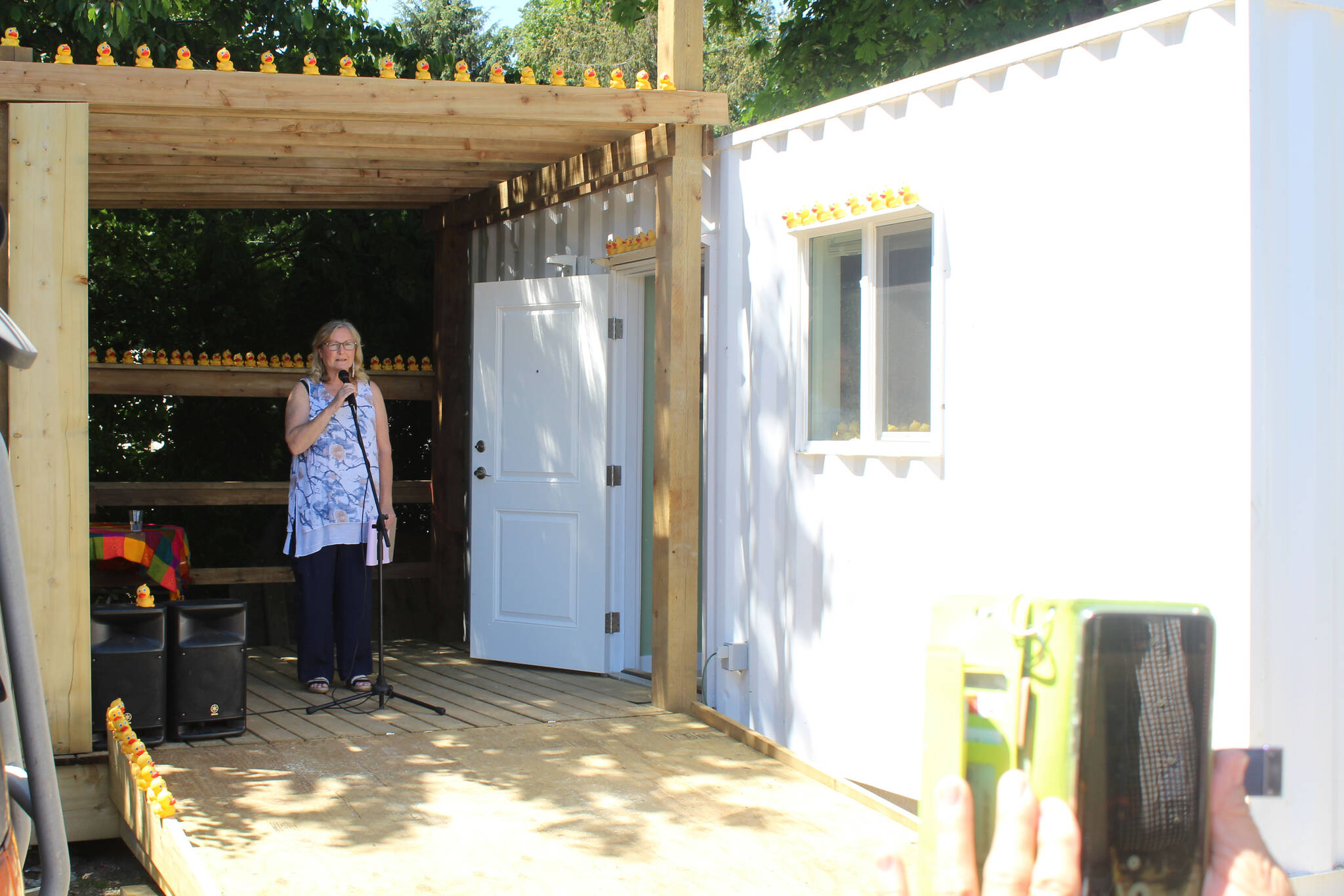 Photo by Terry Farrell
Charlene Davis of Comox Rotary, British Columbia, introduces a shipping container home on June 7, 2020, at the Maple Pool Campground in Courtenay, British Columbia.