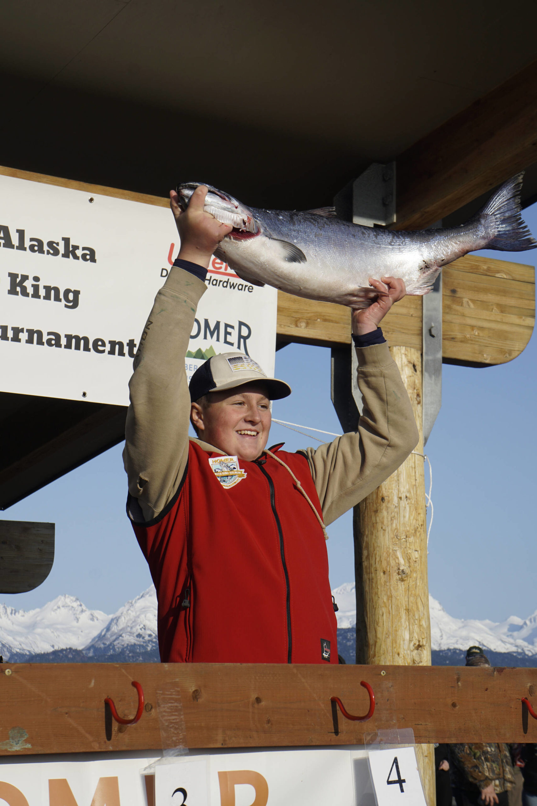 Weston Marley holds up the 27.38-pound winter king salmon he caught to win the 28th annual Homer Winter King Salmon Tournament on Sunday, April 10, 2022, in Kachemak Bay, Homer, Alaska. Marley, 15, fished on the Fly Dough with his father, Jay Marley, and brother, Andrew Marley. It’s the second year a Marley boy won the tournament, with Andrew taking first place for a 25.62-pound king in 2021. (Photo by Michael Armstrong/Homer News)