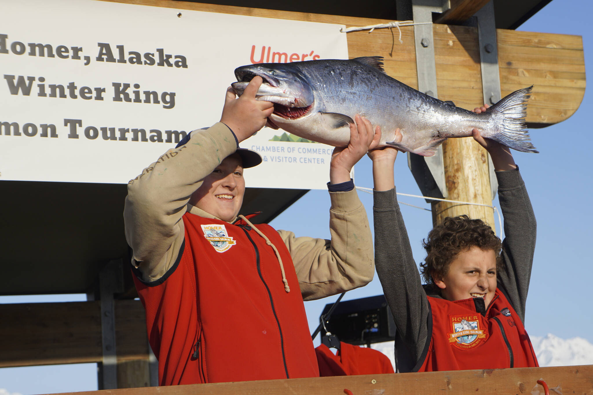 Weston Marley, left, holds up the 27.38-pound winter king salmon he caught to win the 28th annual Homer Winter King Salmon Tournament on Sunday, April 10, 2022, in Kachemak Bay, Homer, Alaska. At right is last year’s champion and Weston’s brother, Andrew Marley, 11 — the youngest angler ever to win the tournament. Weston Marley, 15, fished on the Fly Dough with his father, Jay Marley. (Photo by Michael Armstrong/Homer News)