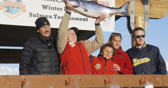 Weston Marley, second from left, holds up the 27.38-pound winter king salmon he caught to win the 28th annual Homer Winter King Salmon Tournament on Sunday, April 10, 2022, in Kachemak Bay, Homer, Alaska. Marley, 15, fished on the Fly Dough with his father, Jay Marley, left, and brother, Andrew Marley, center. Joining them are Zach Marley, far right, and mom Erica Marley, second from right. It's the second year a Marley boy won the tournament, with Andrew taking first place for a 25.62-pound king in 2021. (Photo by Michael Armstrong/Homer News)