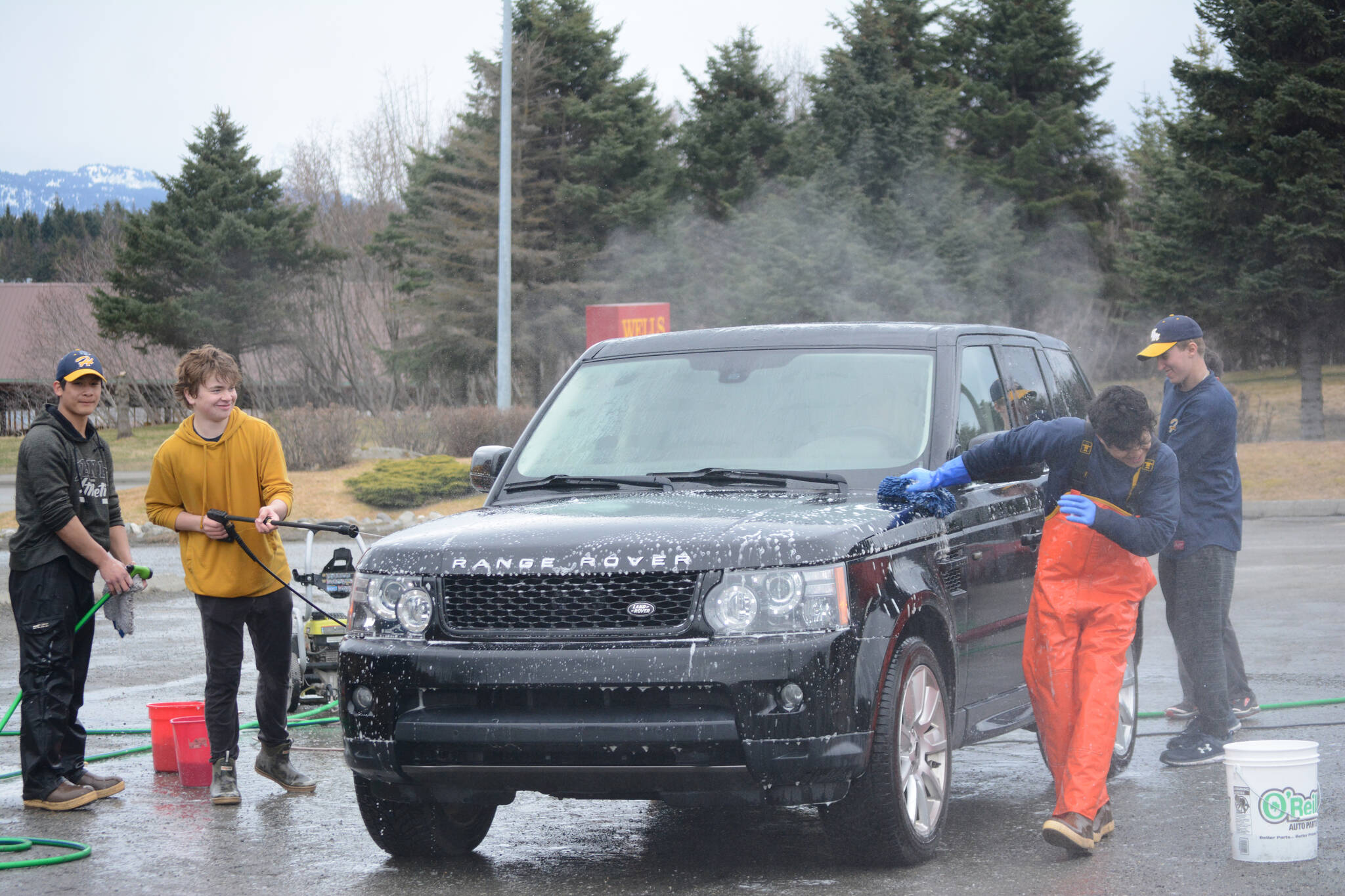 Members of the Homer Mariner baseball team wash cars for a fundraiser on Saturday, April 23, 2022, at Wells Fargo in Homer, Alaska. The Mariners play Friday vs. Redington High School in Wasila and Saturday vs. Barlett and Service in Anchorage. (Photo by Michael Armstrong/Homer News)