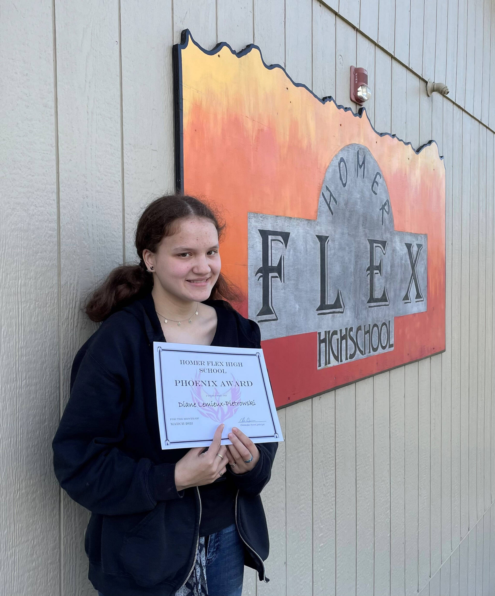 Sophomore Diane Lemieux-Pietrowski, the April recipient of the Homer Flex High School Phoenix Award, poses with her award. (Photo by Beth Schneider)