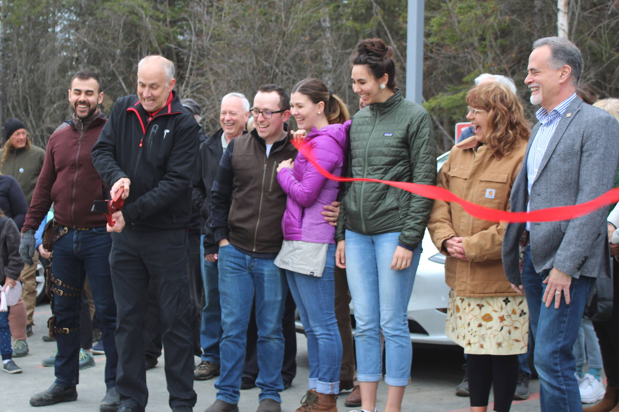 Dr. Henry Krull cuts the ribbon at a ceremony for Alaska’s first Tesla Supercharger station on Saturday, April 30, 2022, in Soldotna, Alaska. (Ashlyn O’Hara/Peninsula Clarion)
