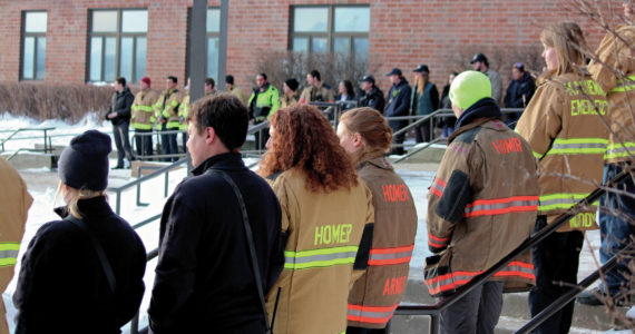 Firefighters and medics lines the steps to Homer High School before a memorial for Gary Thomas on Sunday, Jan.19, 2020 in Homer, Alaska. Thomas, a community advocate and volunteer firefighter for more than 40 years, was found dead this month after a water heater explosion at a home out East End Road. (Photo by Megan Pacer/Homer News)