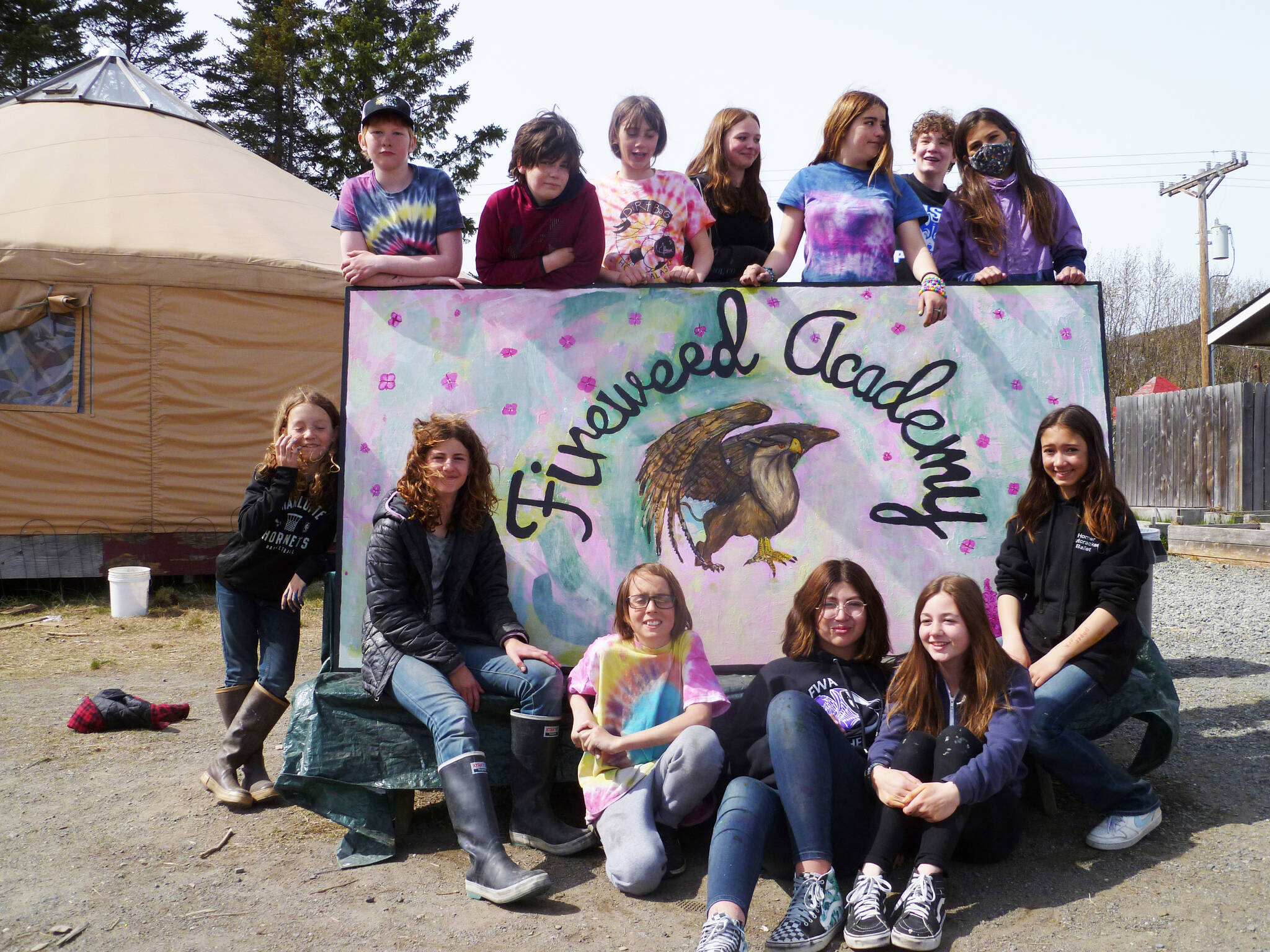 Sixth-grade Fireweed Academy students on Wednesday, May 11, 2022 spent the day working and playing with Little Fireweed students at Little Fireweed Academy in Homer, Alaska. As part of their day, they created a new sign for Big Fireweed with the help of artists Margie Scholl and Sharlyn Young. Posing with the sign are, back row, from left to right, Paul Person, Asher Faucher, Ayda Henry, Mayzie Kee, Ilsa Golden, Olin Braund, and Pearl Sethi. In the front row, from left to right, are Ames Kincaid, Cecily Shavelson, For Strobel, Stella Condon, Izzy Clarke and Ani Cook. (Photo courtesy of Fireweed Academy) Top Row: