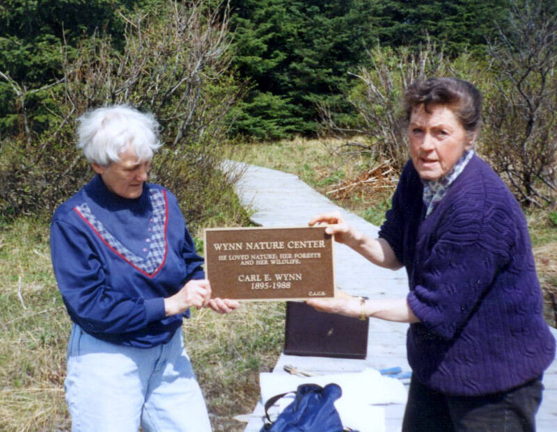 Barbara Hill, left, and Daisy Lee Bitter display a plaque honoring Carl E. Wynn. (Photo courtesy of CACS)