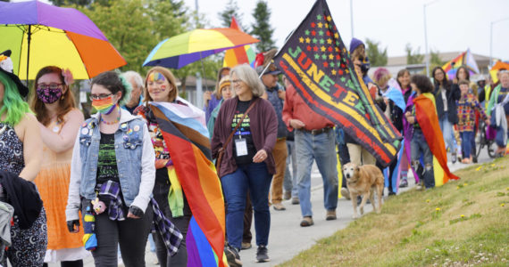 Marchers wearing Pride rainbow colors and carrying Juneteenth flags march in the Pride-X-Juneteenth parade on Saturday, June 18, 2022, on Pioneer Avenue in Homer, Alaska. (Photo by Michael Armstrong/Homer News)