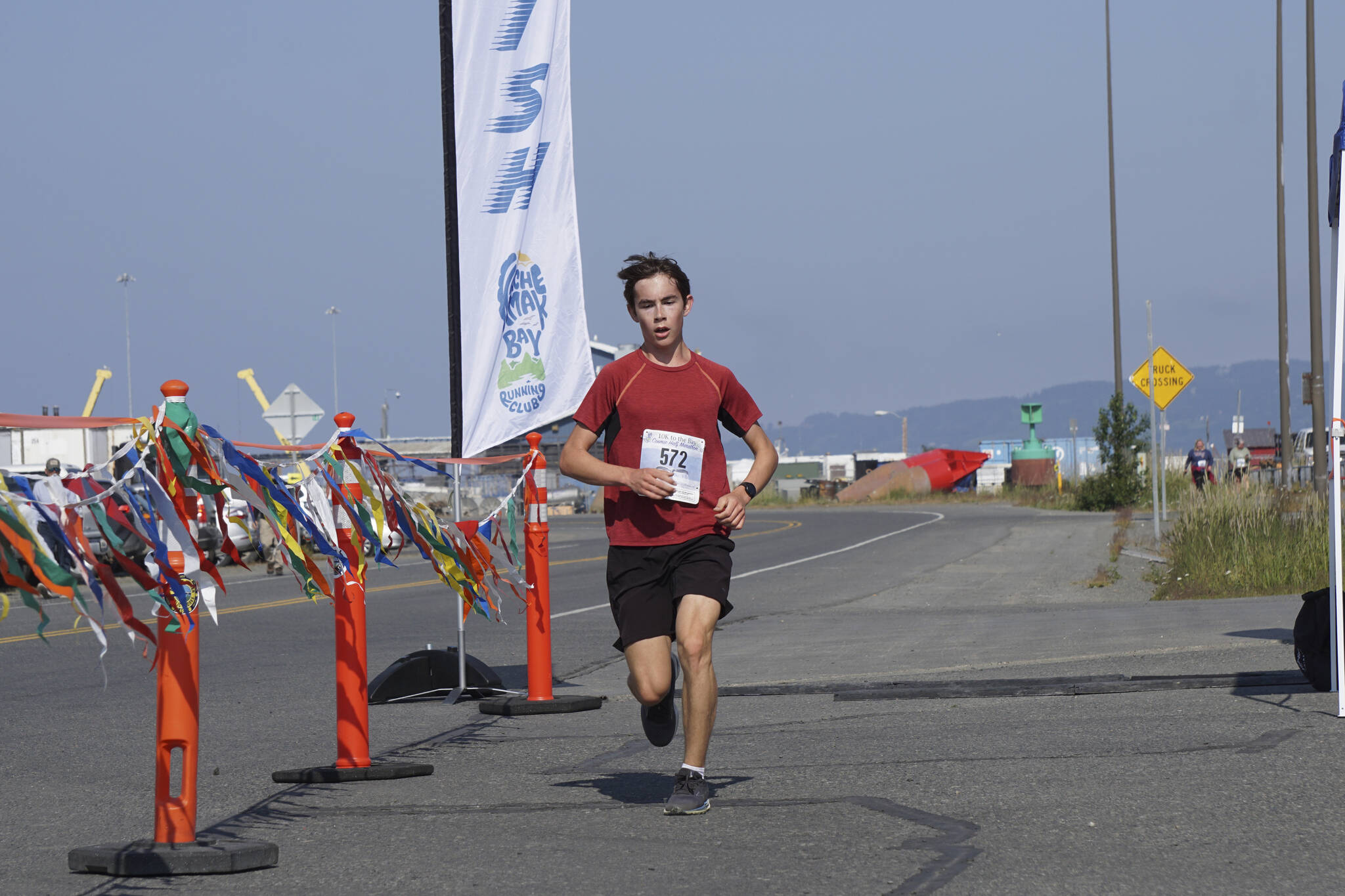 Evan Markelz, the first-place man in the 2022 Homer Spit Run 10k, crosses the finish line on Saturday, June 25, 2022, at the End of the Road Park in Homer, Alaska. (Photo by Michael Armstrong/Homer News)