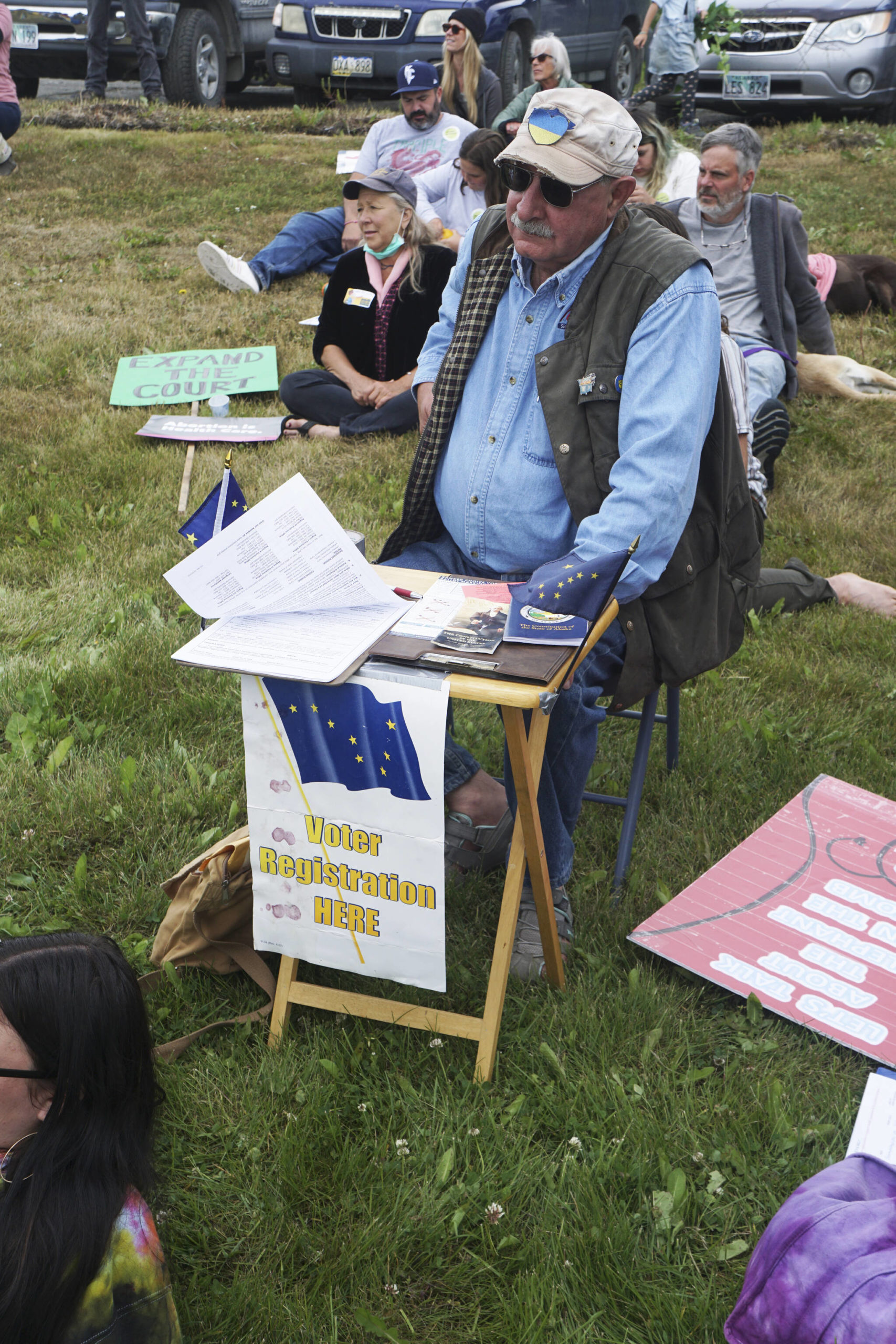 Ken Landfield staffs a voter registration table on Saturday, July 9, 2022, during the “Bans off our bodies” march and protest at WKFL Park in Homer, Alaska. (Photo by Michael Armstrong/Homer News)