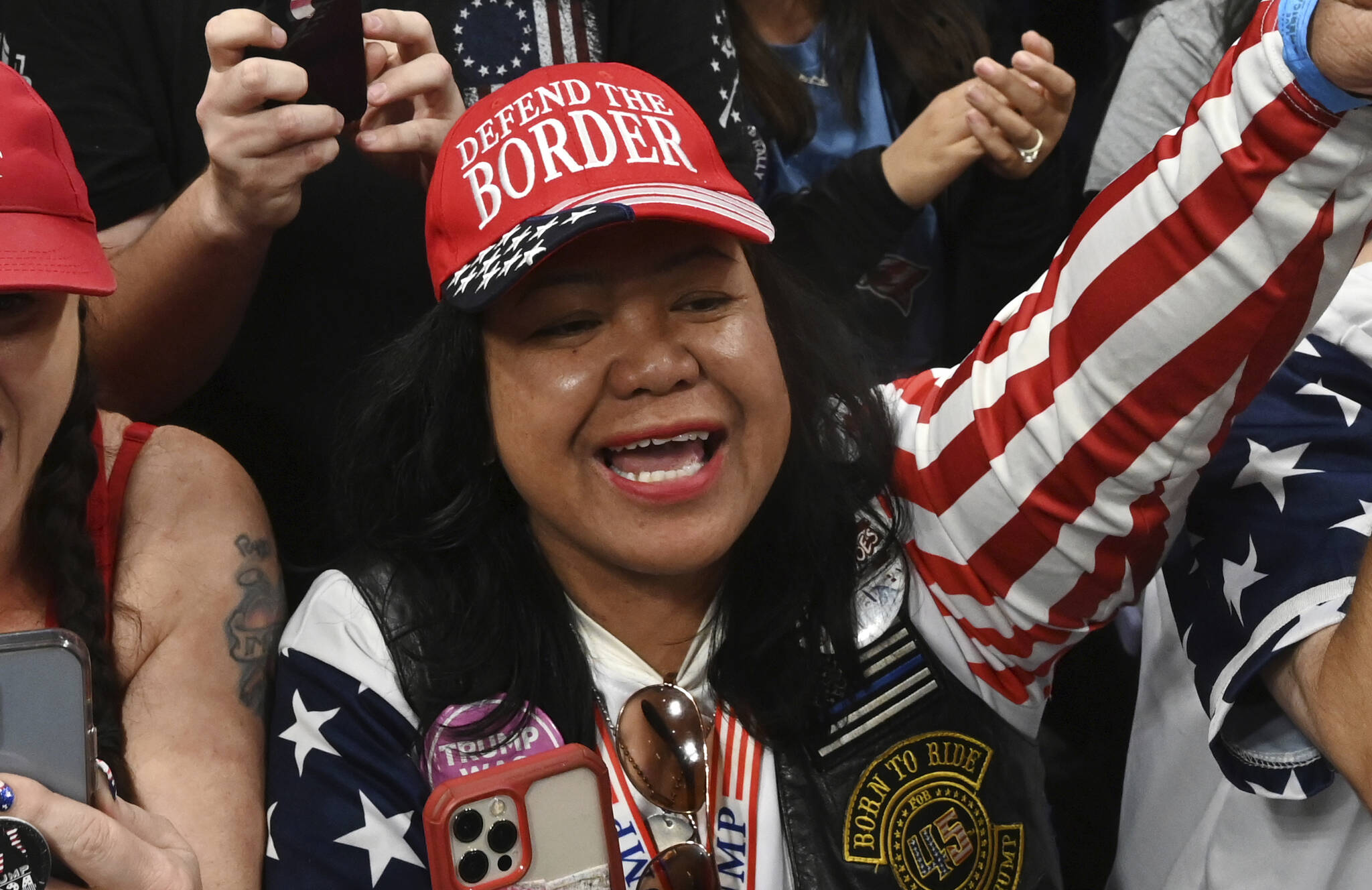 Mimi Israelah, center, cheers for Donald Trump inside the Alaska Airlines Center in Anchorage, Alaska, during a rally Saturday July 9, 2022. An investigation has been launched after a person believed to be an Anchorage, Alaska, police officer was shown in a photo with Israelah flashing a novelty “White Privilege card.” The social media post caused concerns about racial equality in Alaska’s largest city.  (Bill Roth / Anchorage Daily News)