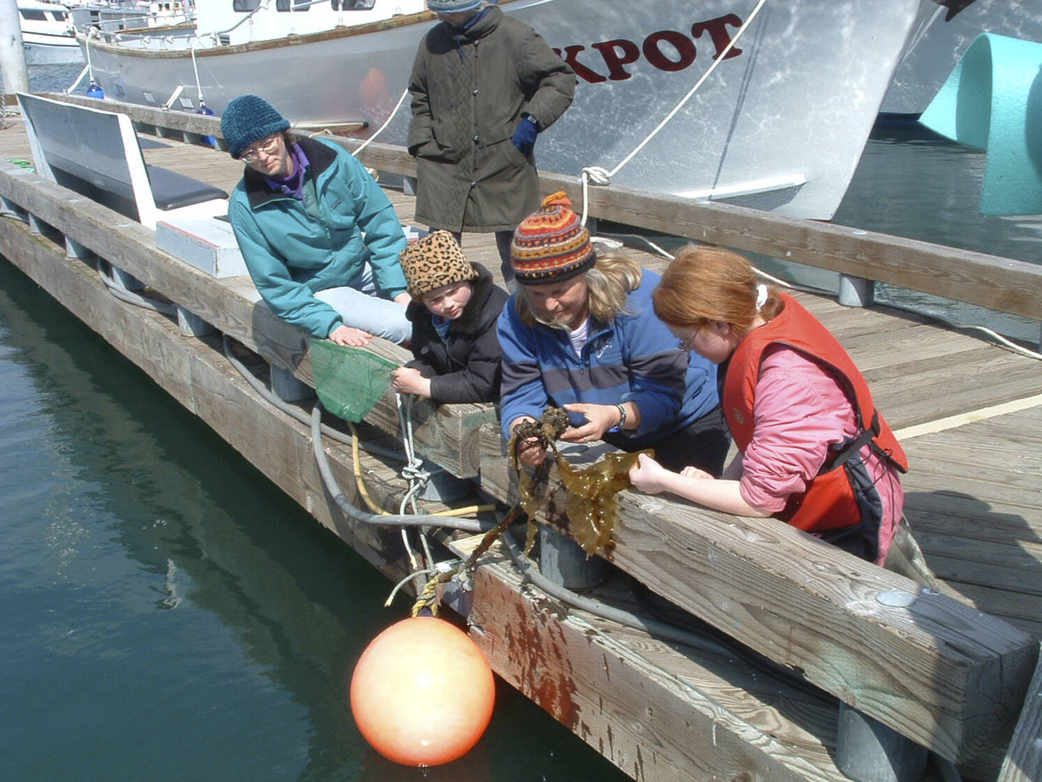 Lori Holcomb of Talkeetna and daughters Heather and Heidi are introduced to "Creatures of the Dock" during a Saturday tour led in May 2007 by Marilyn Sigman (center), director of Center for Alaskan Coastal Studies. (Courtesy photo/Center for Alaskan Coastal Studies)