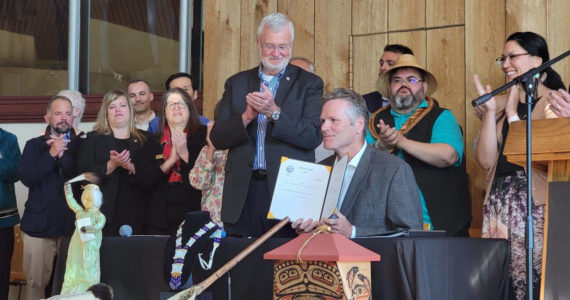 Gov. Mike Dunleavy, center, holds a copy of House Bill 123, providing state recognition for Alaska’s 229 federally recognized Native tribes, at an event hosted by the Alaska Federation of Natives in Anchorage, Alaska, on Thursday, July 28, 2022. (Photo provided by the Alaska Federation of Natives)