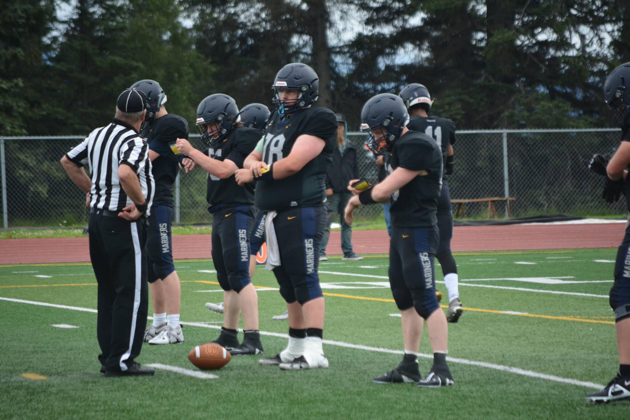 The Mariner’s offensive line coordinates their attack on Saturday, Aug. 13, 2022, at Homer High School in Homer, Alaska. (Photo by Charlie Menke/ Homer News)