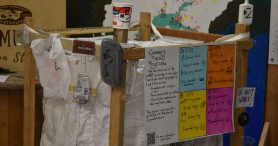 Signs and examples on the recycling super sack at the Cook Inletkeeper Community Action Studio show which plastics are desired as part of the project in Soldotna, Alaska, on Aug. 11, 2022. Plastics from types 1, 2, 4 and 5 can be deposited.(Jake Dye/Peninsula Clarion)