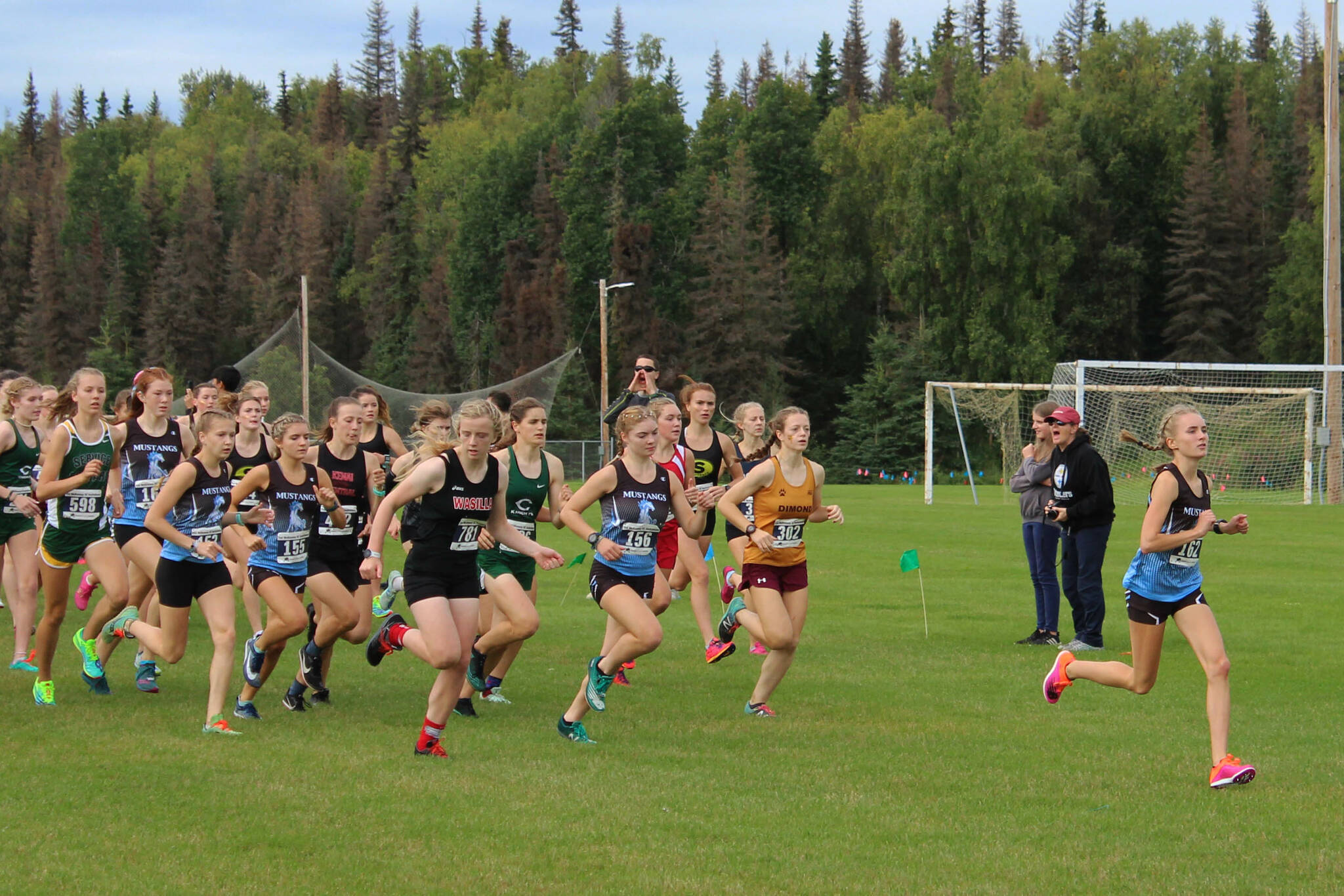 Chugiak High School’s Cameron Peterson (right) leads the girls varsity pack at the 2022 Ted McKenney XC Running Invitational at Tsalteshi Trails at Skyview Middle School on Saturday, Aug. 20, 2022, in Soldotna, Alaska. (Ashlyn O’Hara/Peninsula Clarion)
