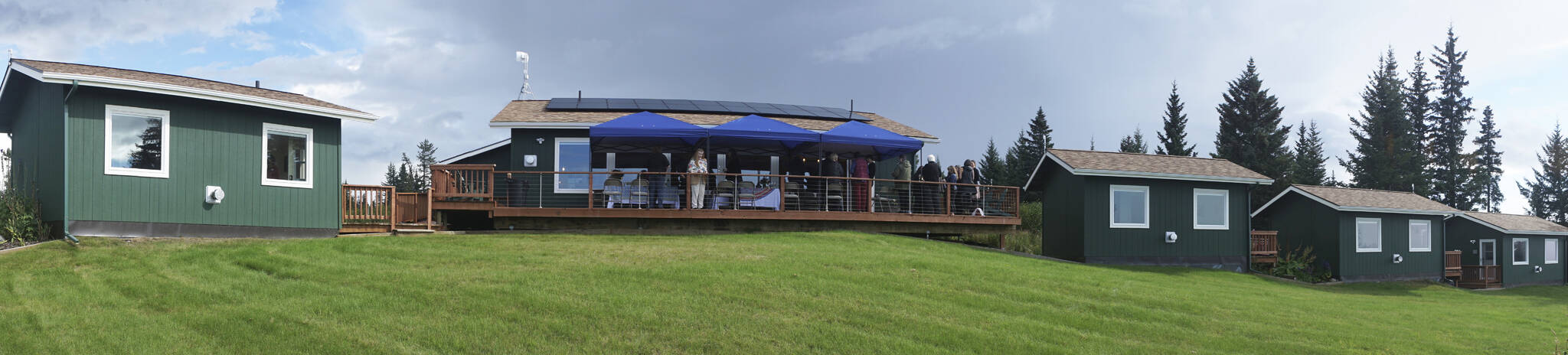 Visitors gather on the deck of Eva, the main house of the Storyknife Writers Retreat, on Monday, Aug. 29, 2022, for an open house. The six writers cabins are on either side of Eva. (Photo by Michael Armstrong/Homer News)