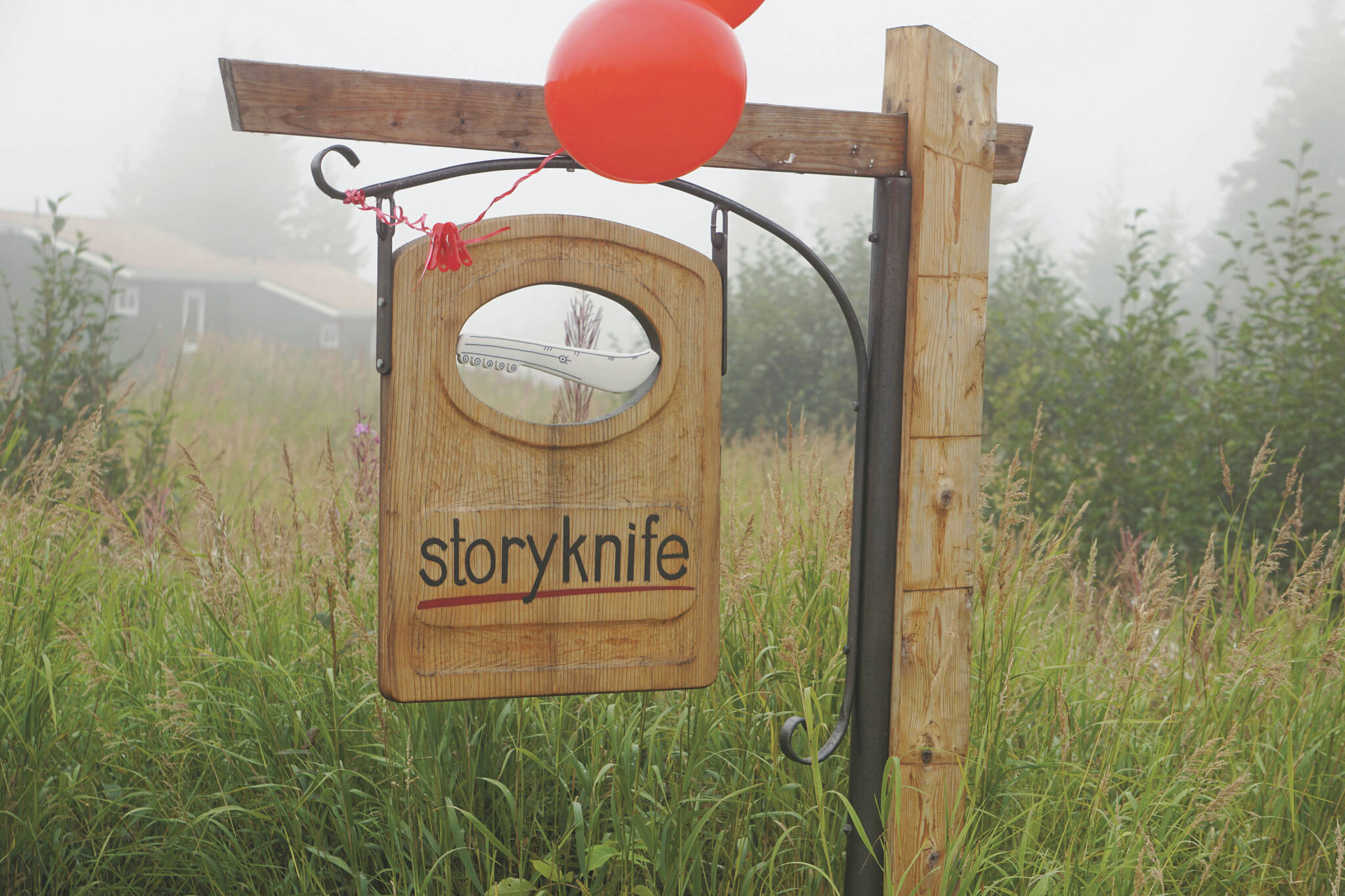 Fog rolls in over the sign for the Storyknife Writers Retreat at an open house on Monday, Aug. 29, near Homer.