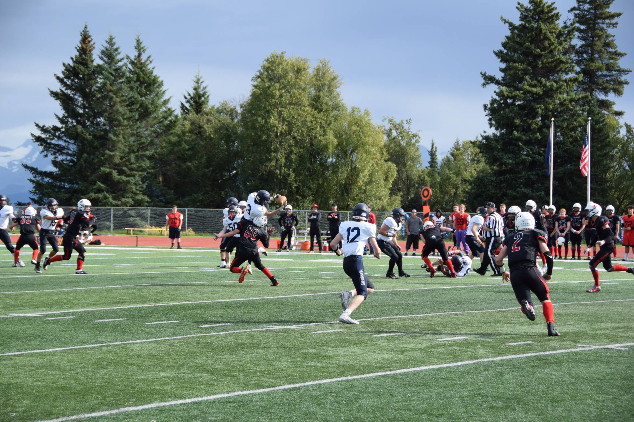 Martin catches the ball while being tackled on Saturday, Sep. 3, at the Homer High School Field in Homer, Alaska. (Photo by Charlie Menke/ Homer News)