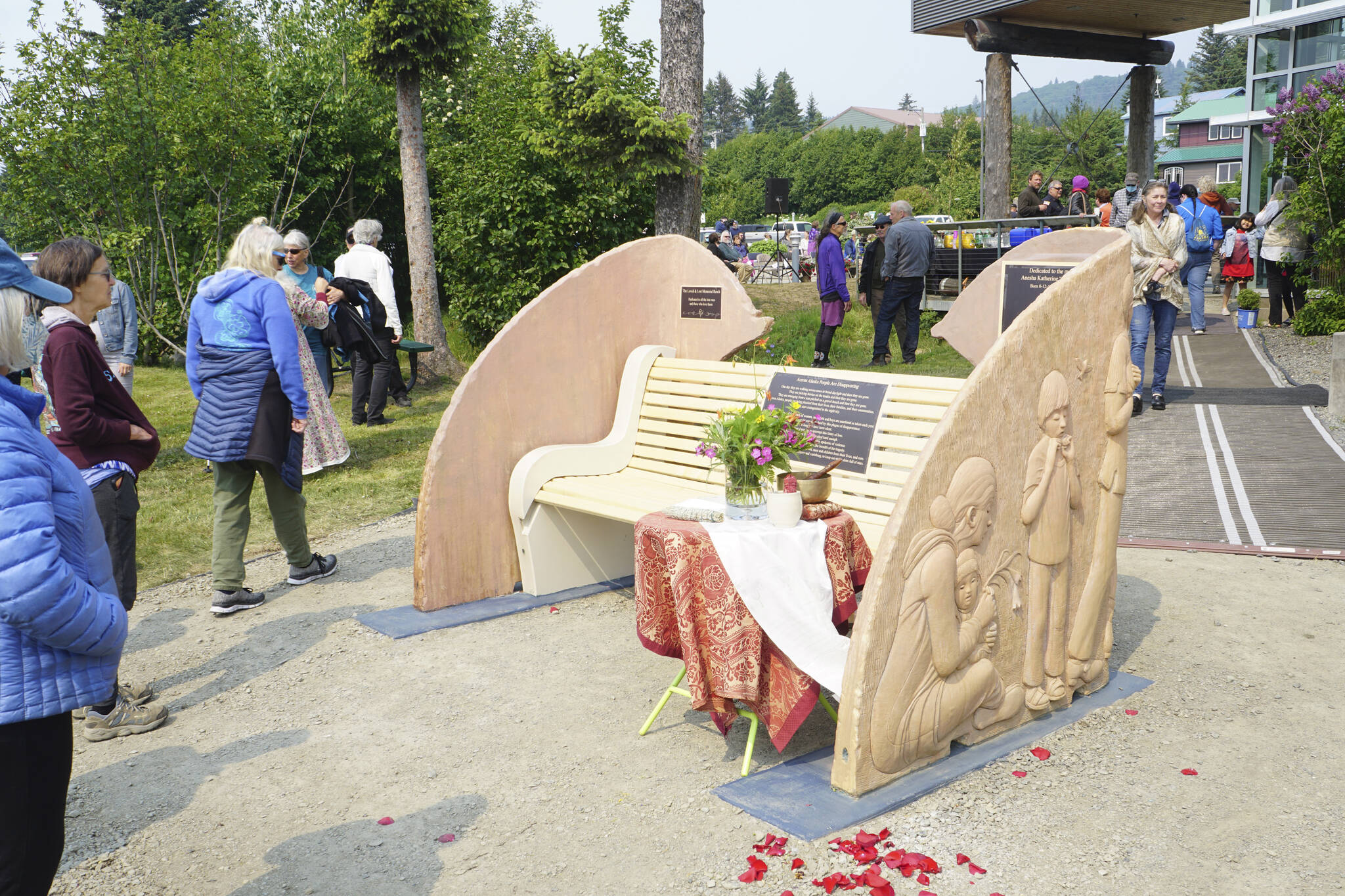 People visit at the Loved & Lost Memorial Bench on Sunday, June 12, 2022, at the Homer Public Library in Homer, Alaska, for a memorial for Anesha "Duffy" Murnane and the dedication of the bench. (Photo by Michael Armstrong/Homer News)