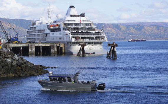 A fishing boat passes the Silversea cruise ship Silver Wind as the boat enters the Homer Harbor on Sunday, Sept. 25, 2022, in Homer, Alaska. (Photo by Michael Armstrong/Homer News)