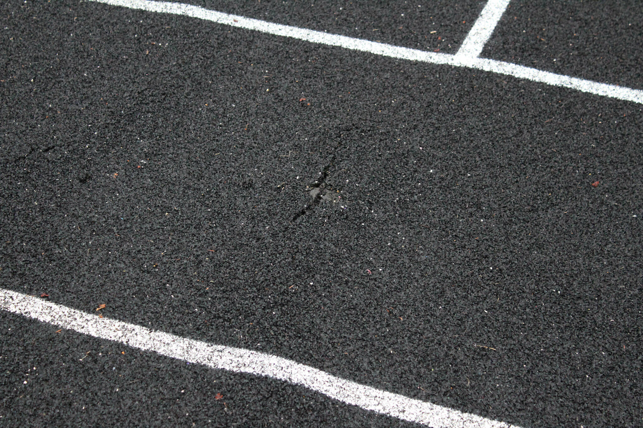 A crack warps the track at Nikiski Middle/High School on Monday, Sept. 19, 2022, in Nikiski, Alaska. The track is one of several projects in a bond package Kenai Peninsula voters will consider during the Oct. 4 municipal election next month. (Ashlyn O’Hara/Peninsula Clarion)
