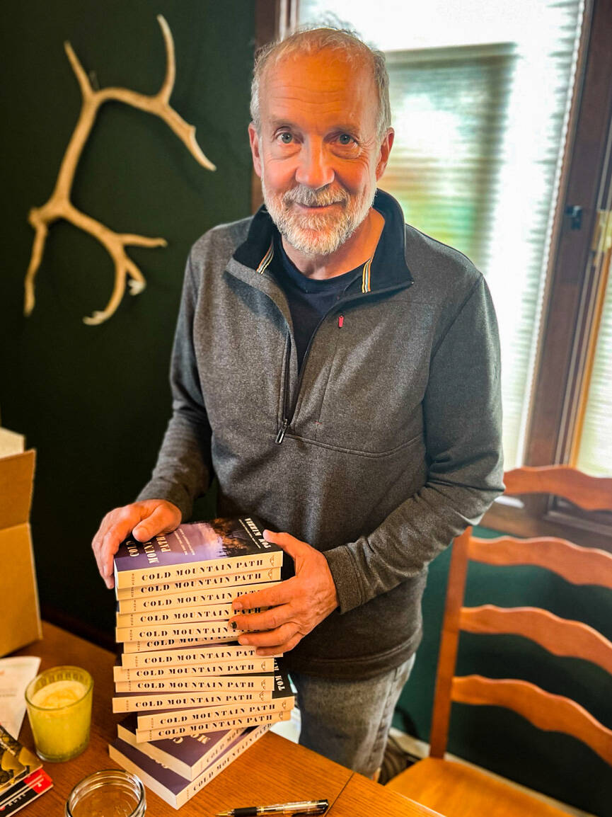 Tom Kizzia poses with a stack of his book, “Cold Mountain Path,” on Sept. 1, 2021. (Photo provided)