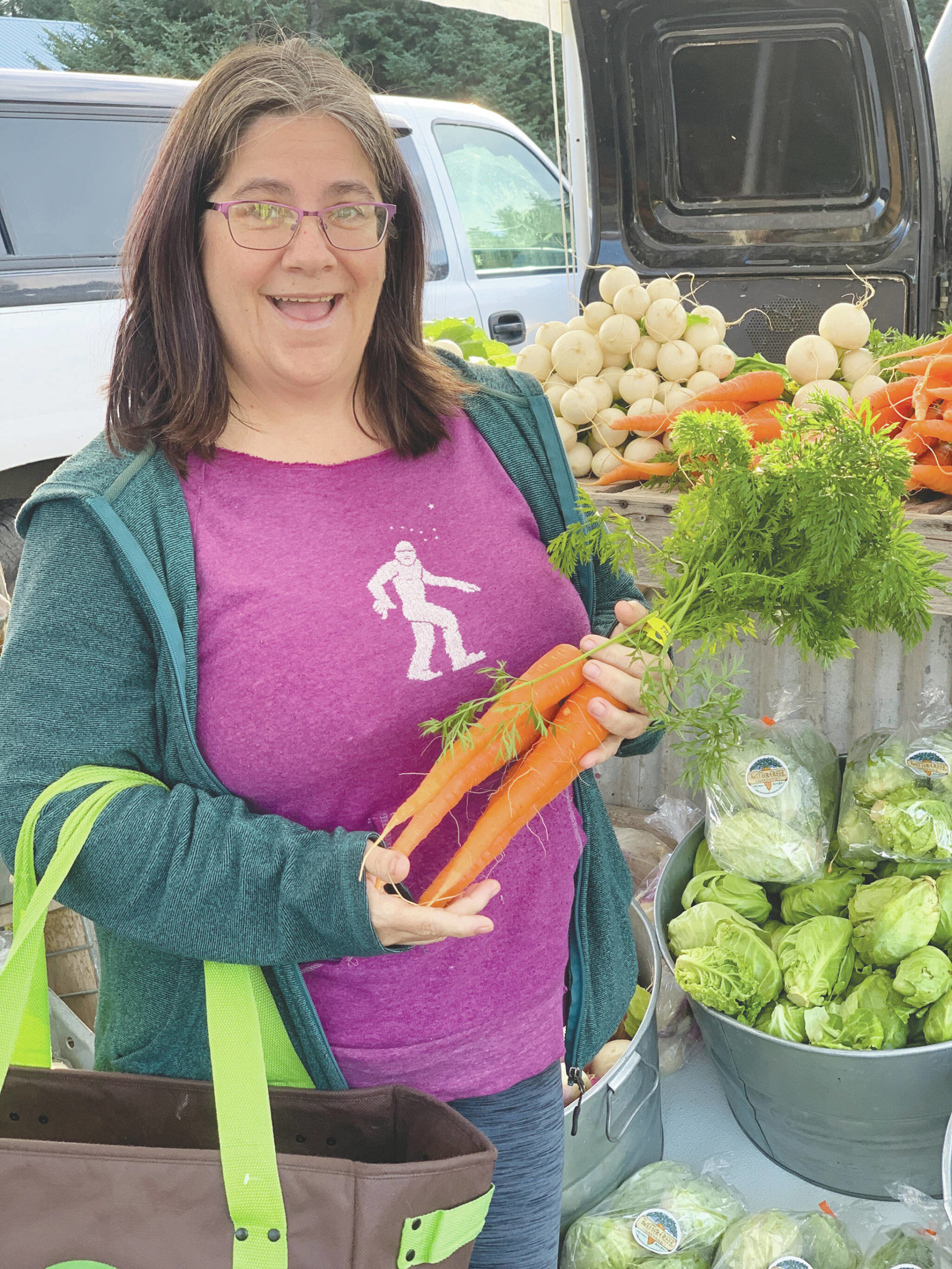 Homer resident Beth Carroll visits the Twitter Creek Farms booth at the Homer Farmers Market on Sunday, Oct. 15, 2022, in Homer, Alaska. A few vendors are still selling on Saturdays and Wednesdays. (Photo by Christina Whiting)