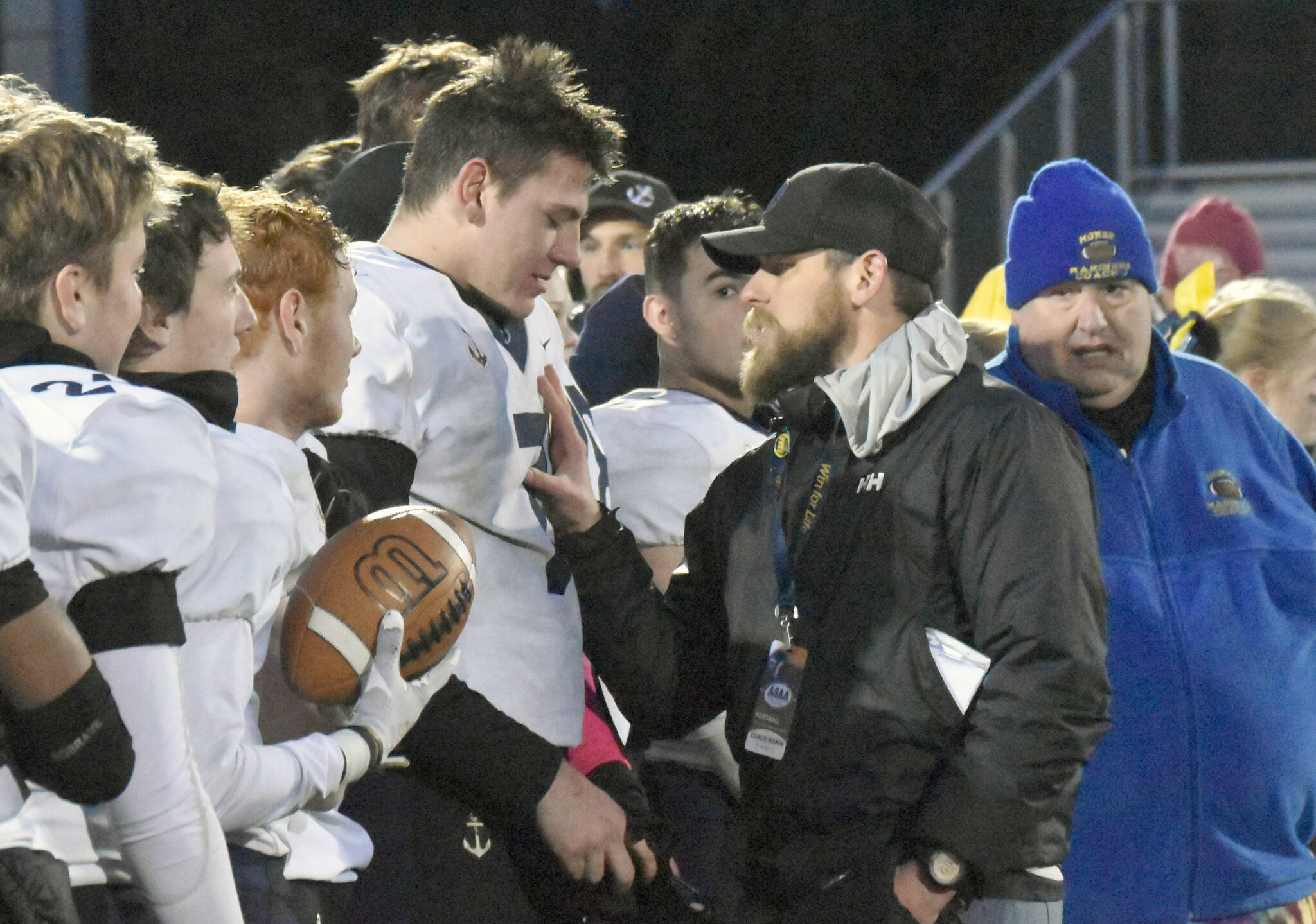 Homer head coach Justin Zank shares a moment with quarterback Carter Tennison after winning the Division III state championship Saturday, Oct. 15, 2022, at Service High School in Anchorage, Alaska. (Photo by Jeff Helminiak/Peninsula Clarion)