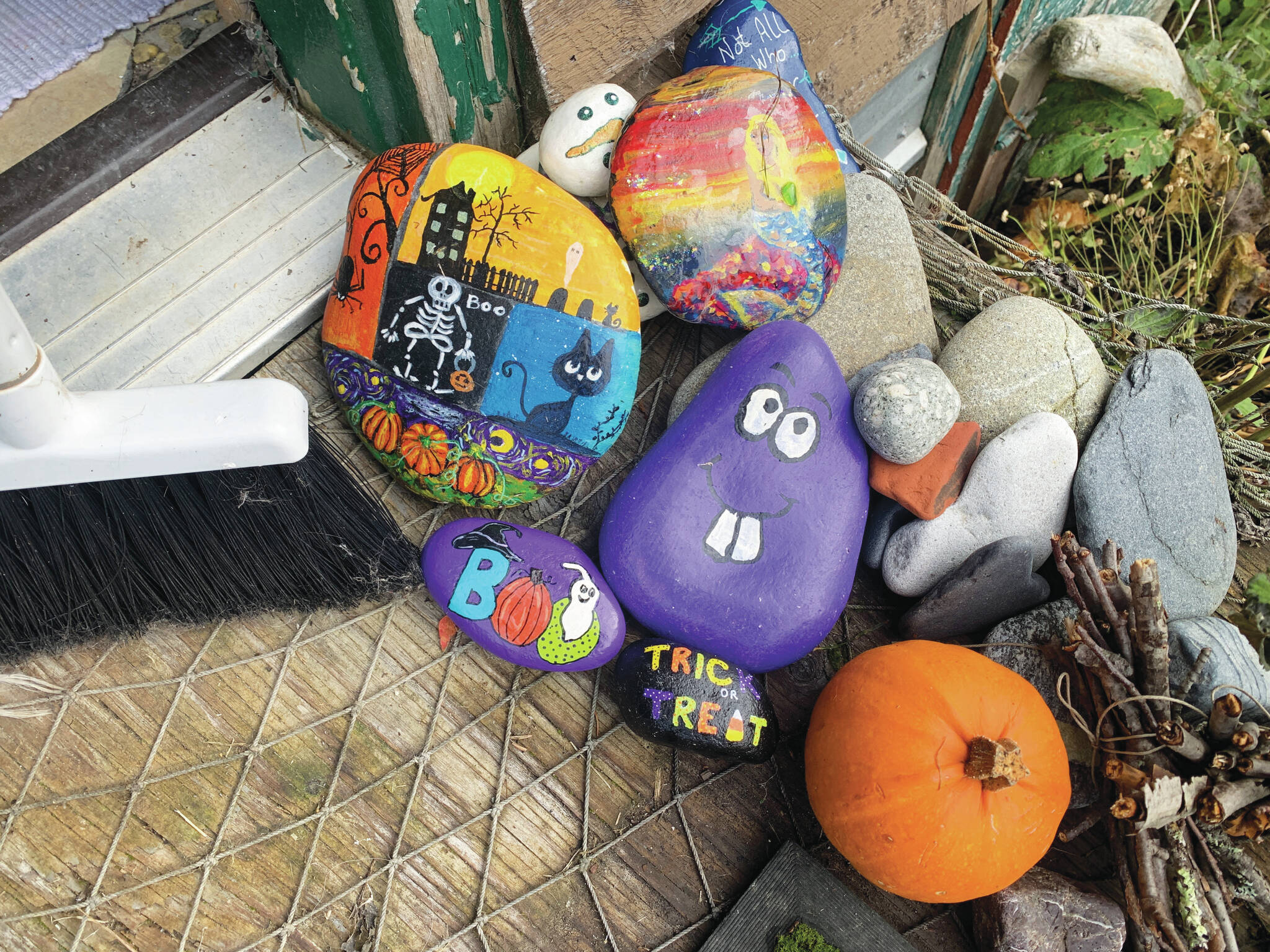 A festive doorway includes a pumpkin, broom and painted rocks by Homer Rocks and Anchorage rocks members, photo by Christina Whiting